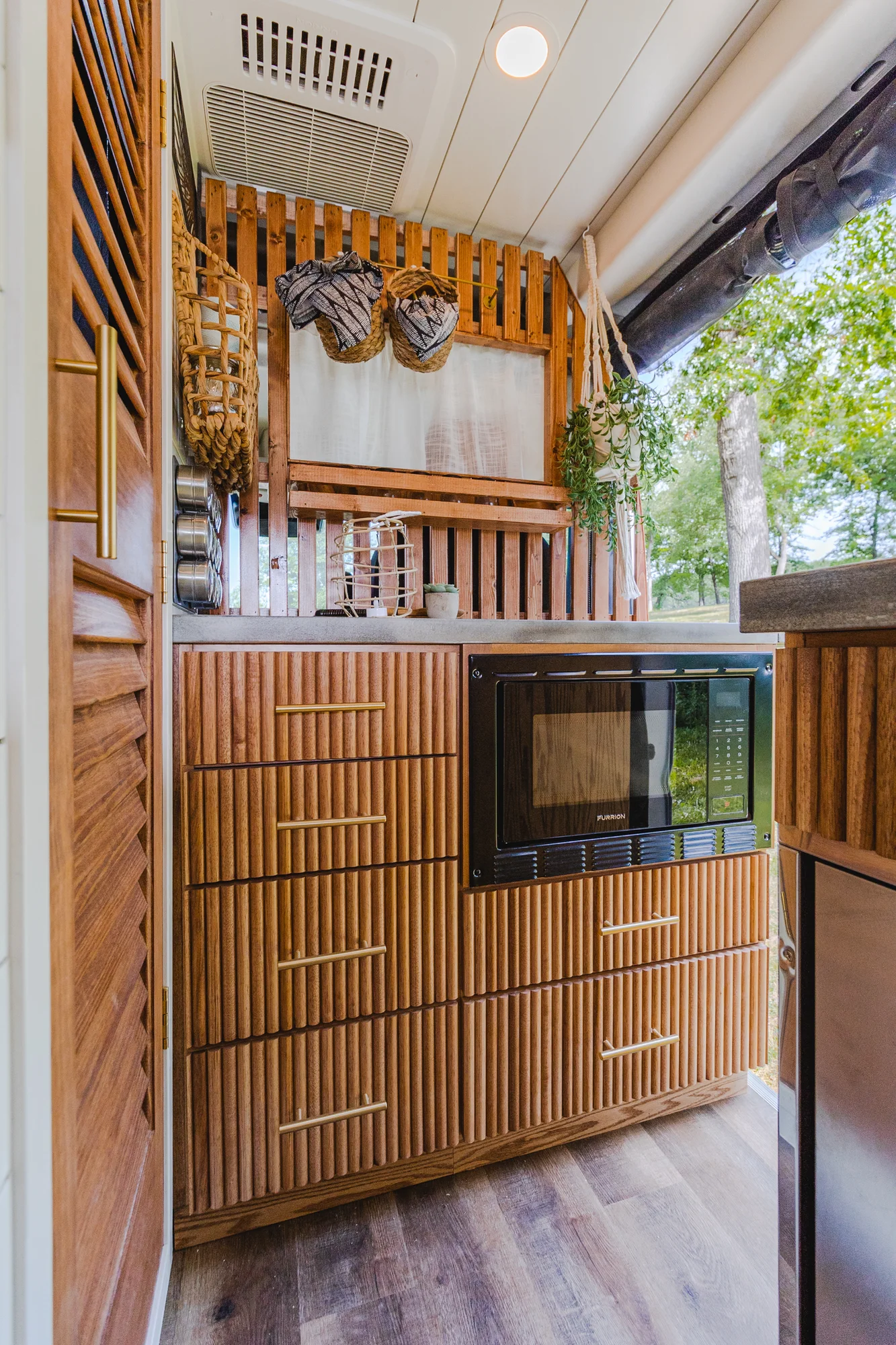 The Drifter 101 custom Ram ProMaster campervan built for Tracy by Drifter Vans, with an earthy boho interior, gold showerhead, and warm wood paneling