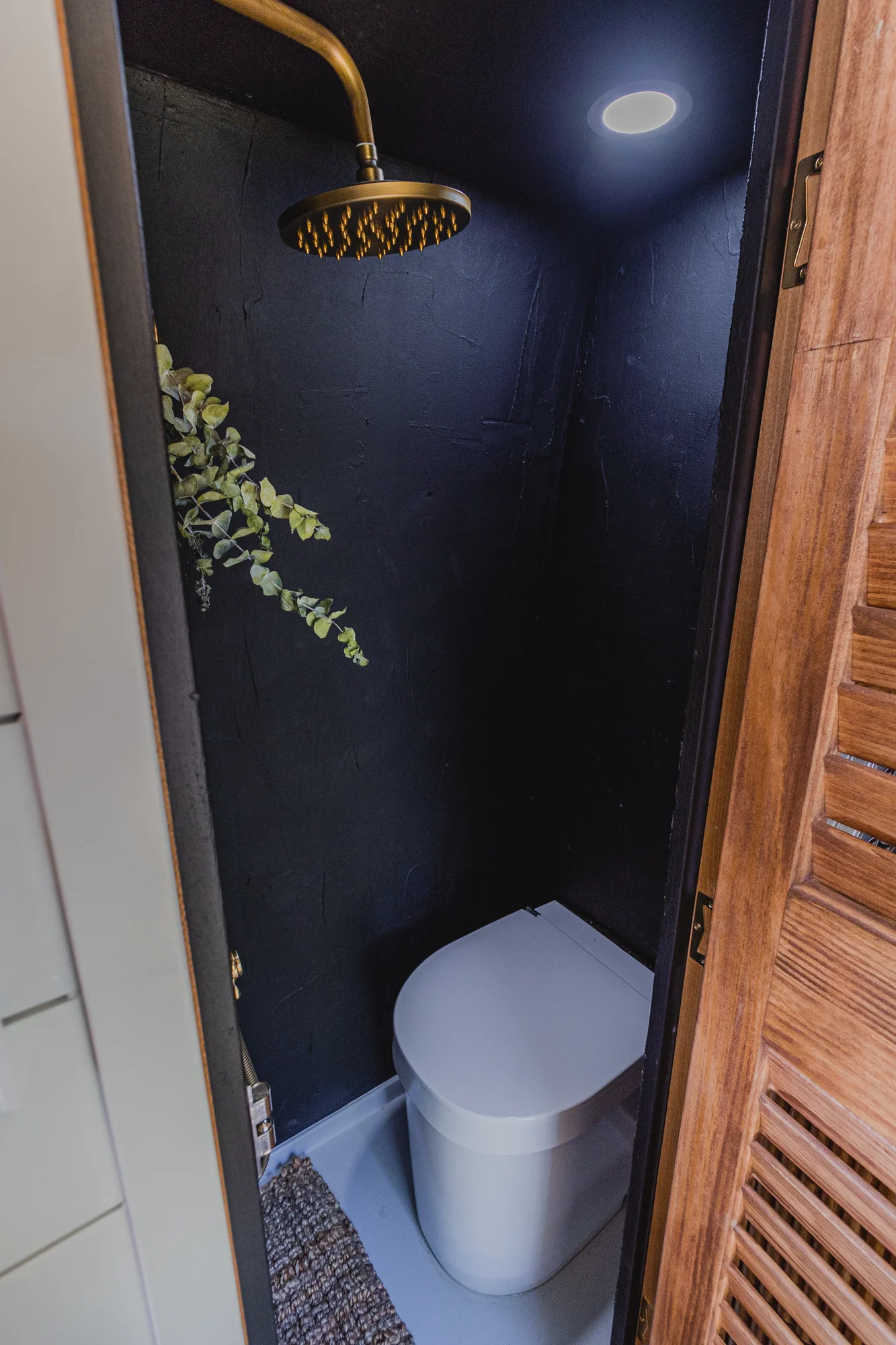 The Drifter 101 custom Ram ProMaster campervan built for Tracy by Drifter Vans, with an earthy boho interior, gold showerhead, and warm wood paneling