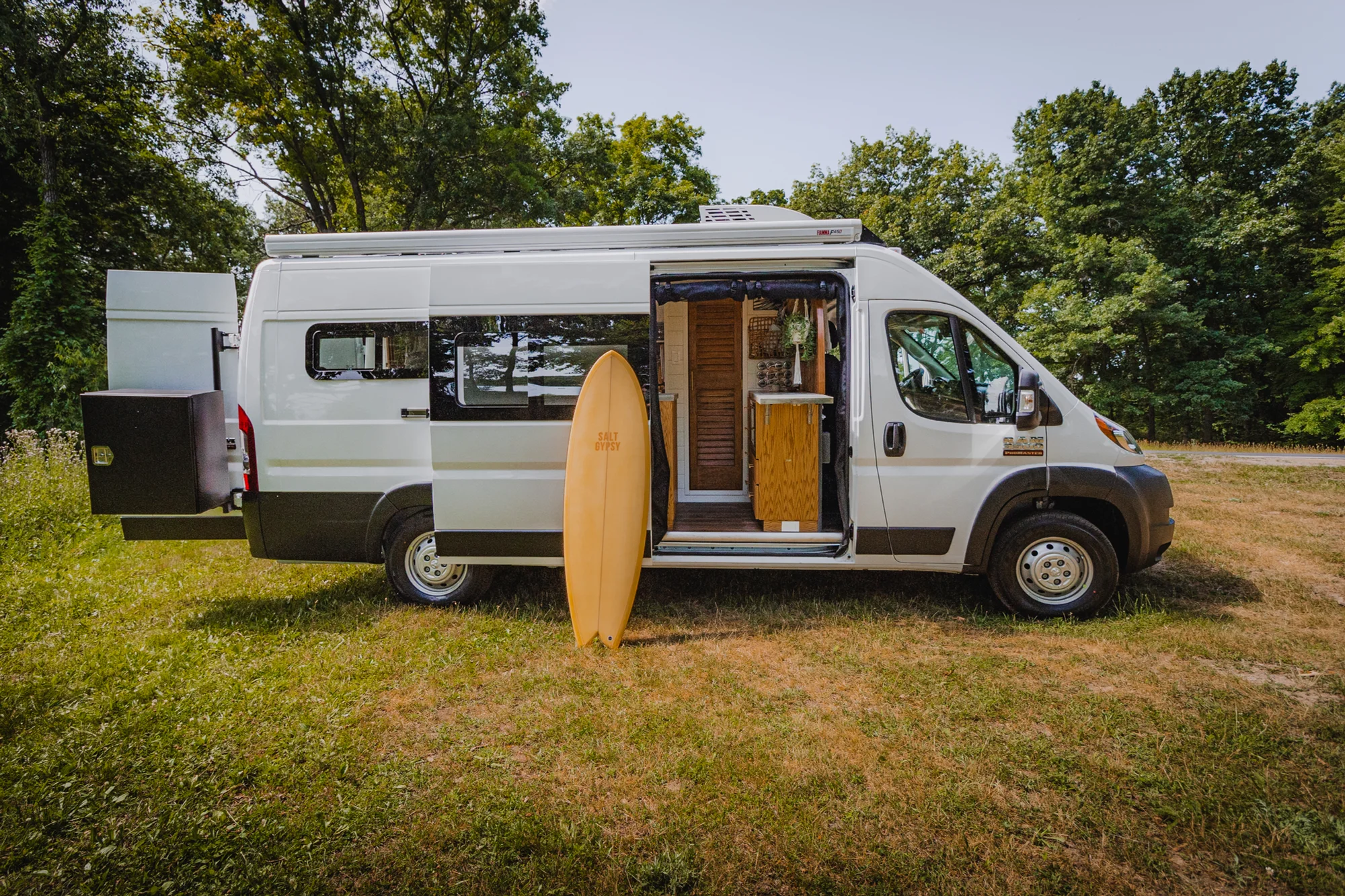 The Drifter 101 custom Ram ProMaster campervan built for Tracy by Drifter Vans, with an earthy boho interior, gold showerhead, and warm wood paneling