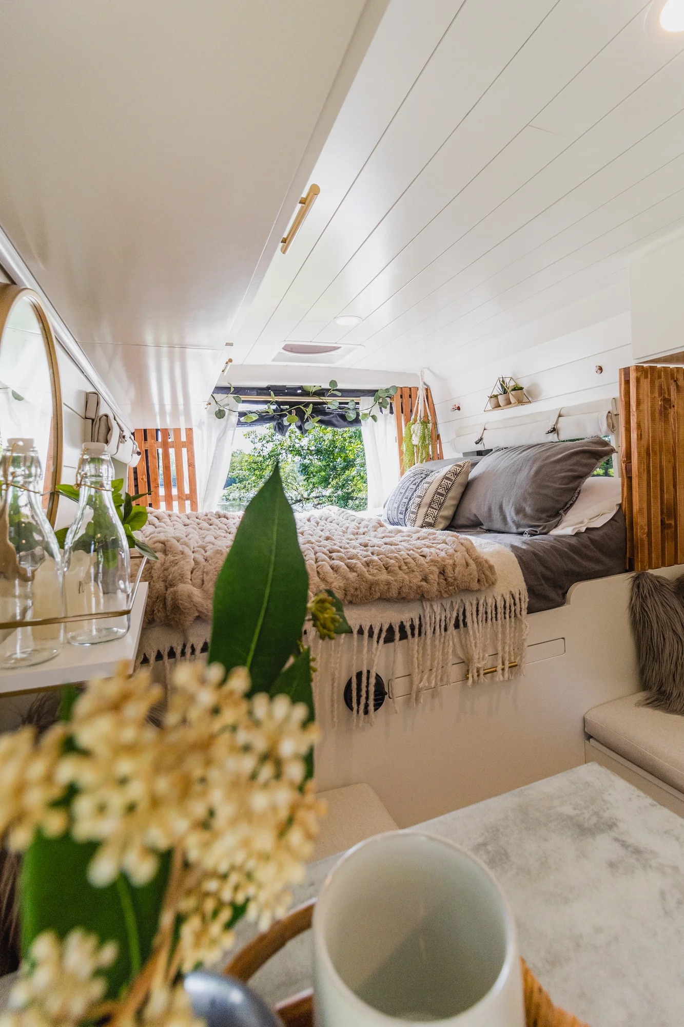 The Drifter 101 custom Ram ProMaster campervan built for Tracy by Drifter Vans, with an earthy boho interior, gold showerhead, and warm wood paneling