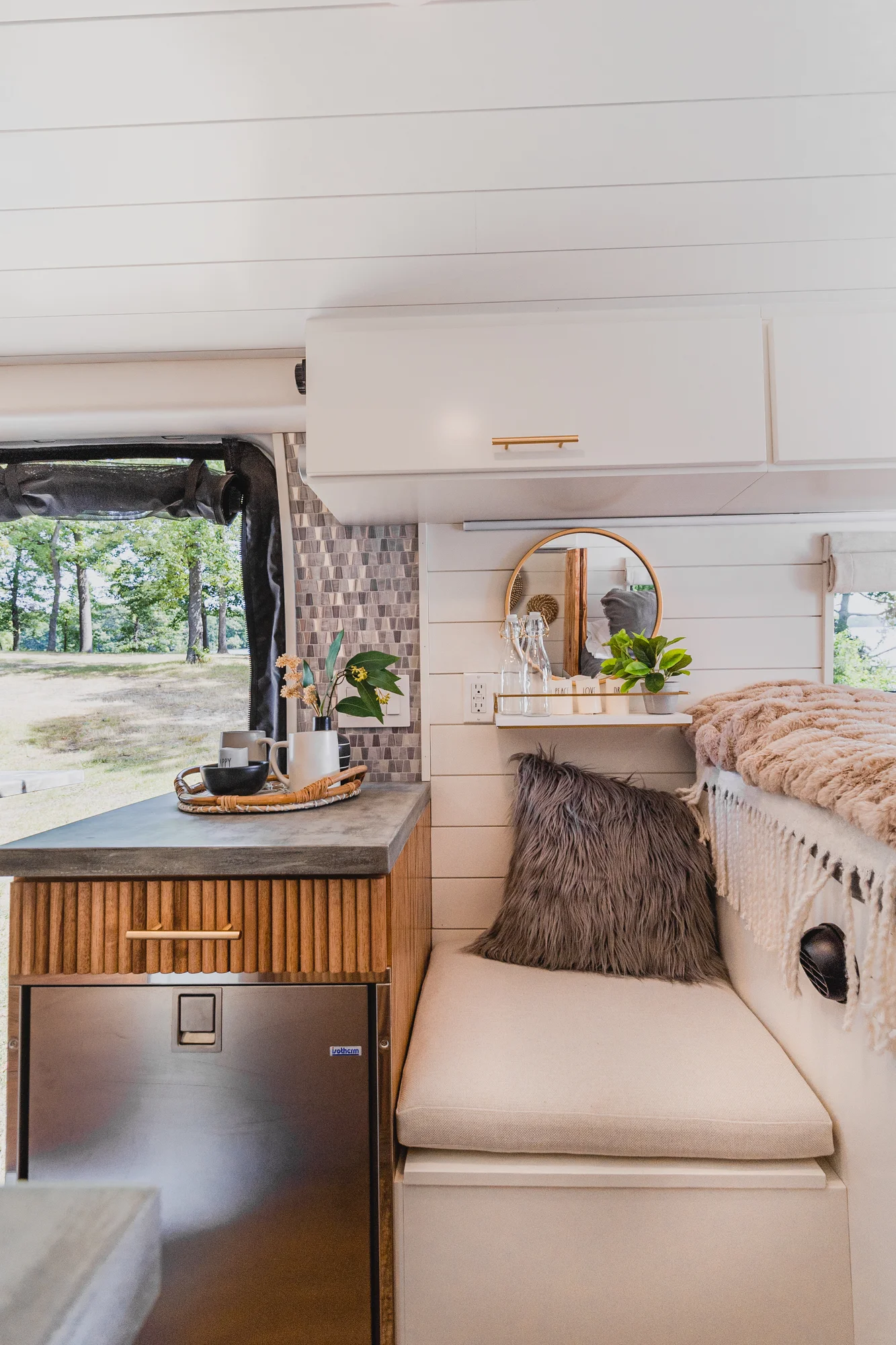 The Drifter 101 custom Ram ProMaster campervan built for Tracy by Drifter Vans, with an earthy boho interior, gold showerhead, and warm wood paneling