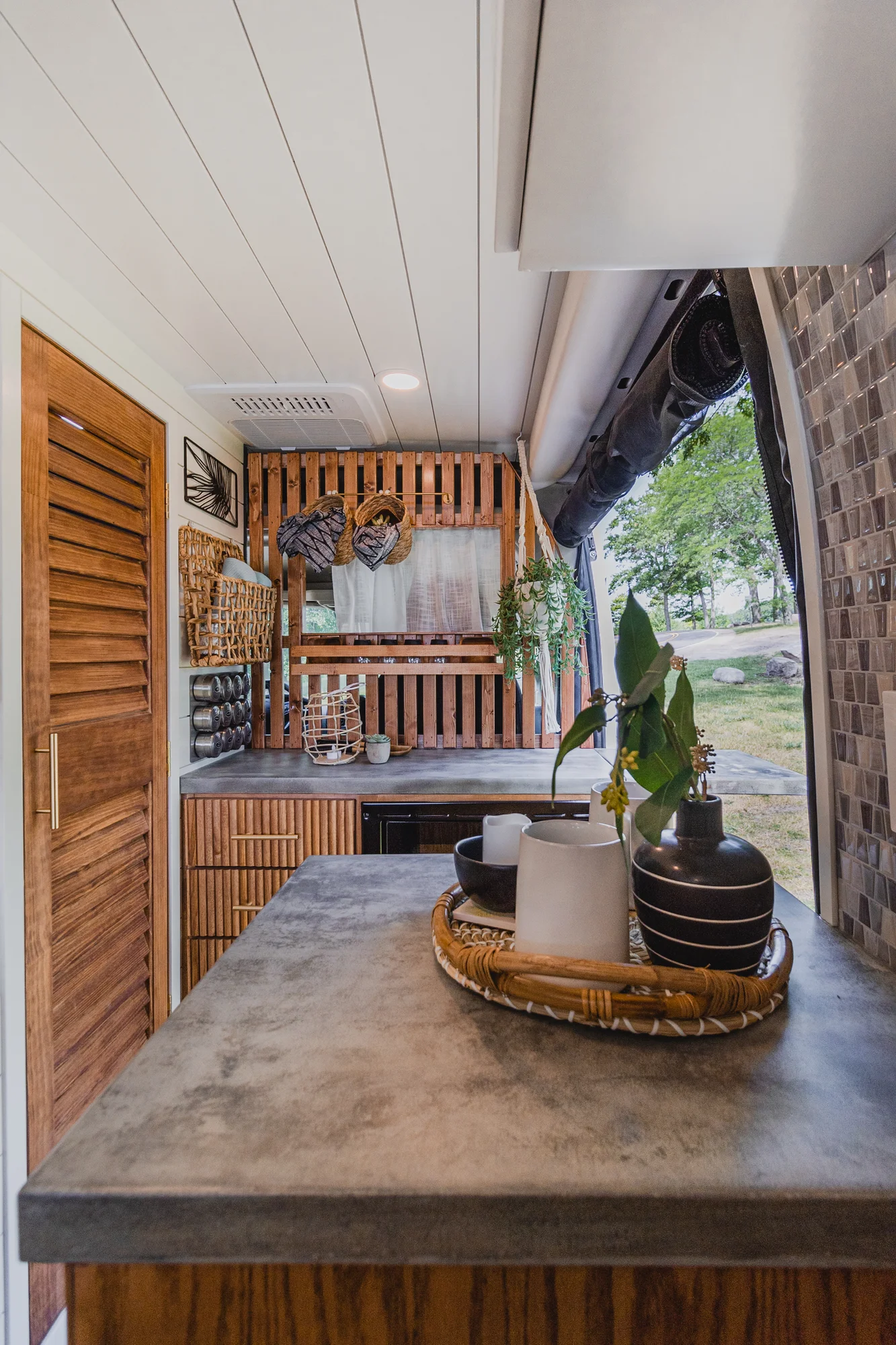 The Drifter 101 custom Ram ProMaster campervan built for Tracy by Drifter Vans, with an earthy boho interior, gold showerhead, and warm wood paneling