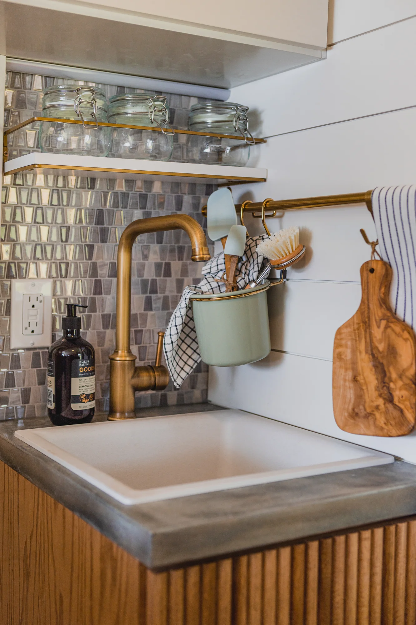 The Drifter 101 custom Ram ProMaster campervan built for Tracy by Drifter Vans, with an earthy boho interior, gold showerhead, and warm wood paneling