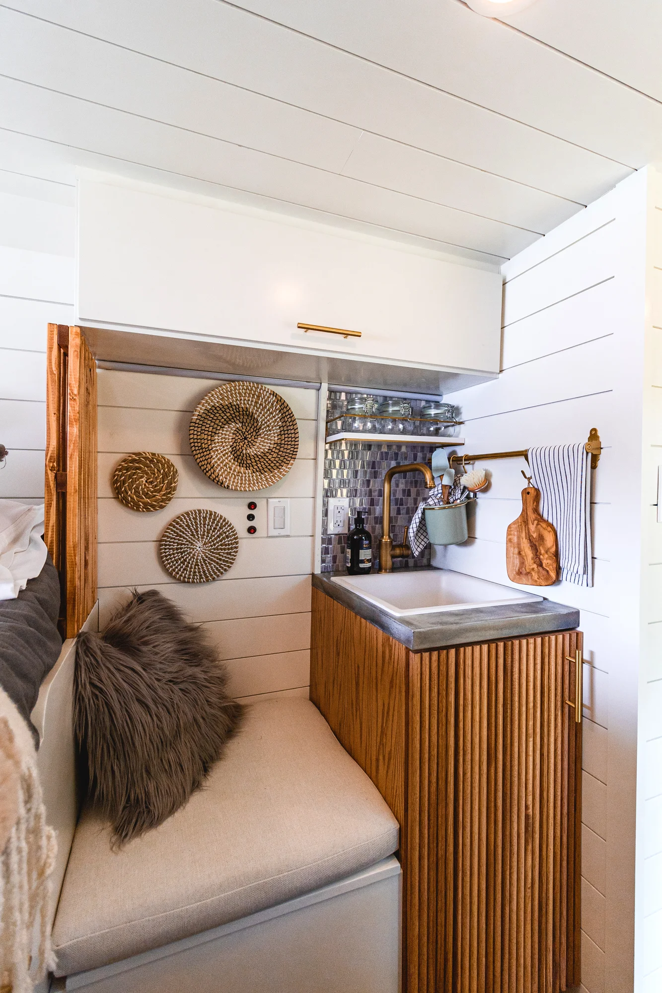 The Drifter 101 custom Ram ProMaster campervan built for Tracy by Drifter Vans, with an earthy boho interior, gold showerhead, and warm wood paneling