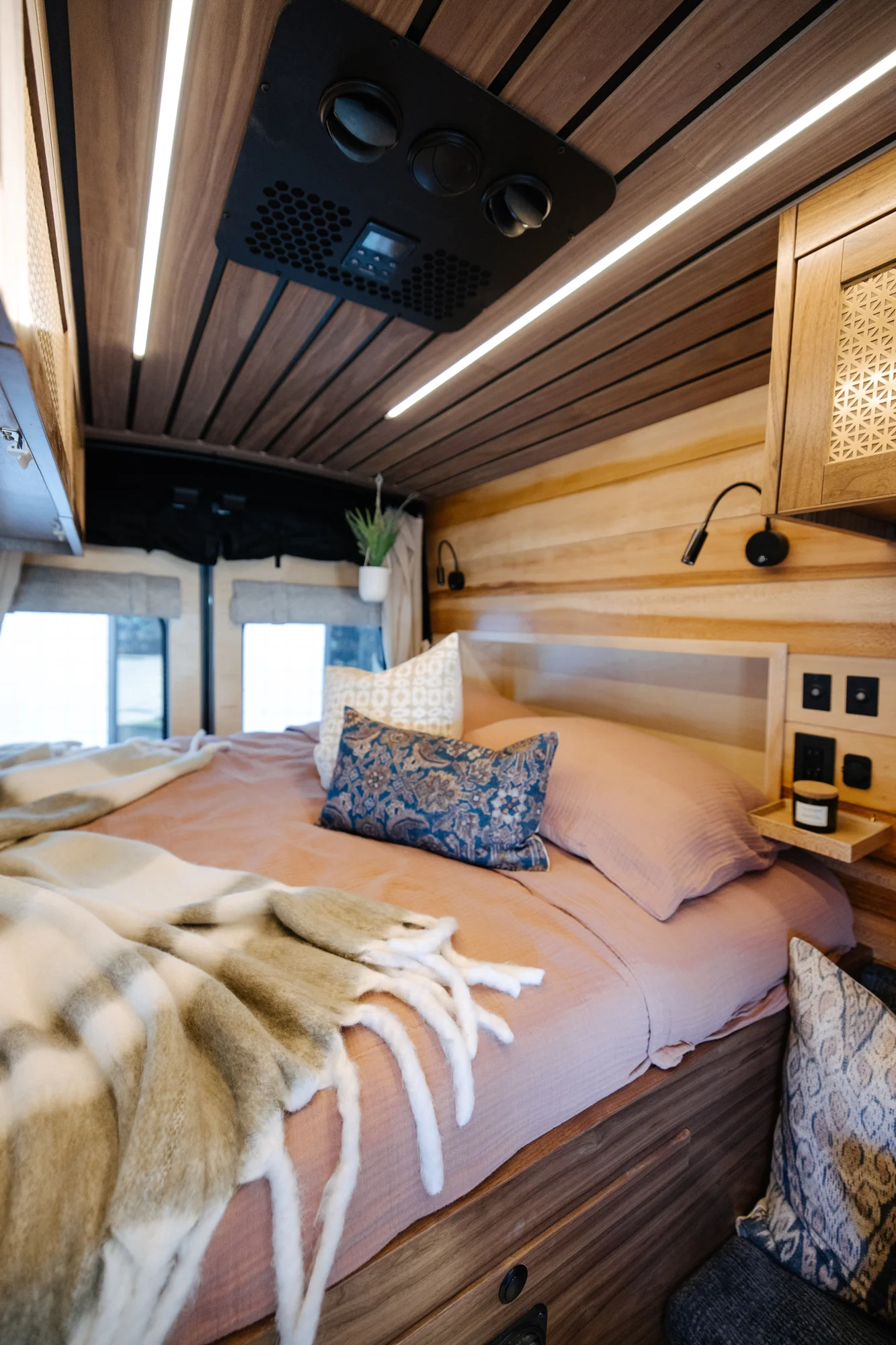 The Drifter 101 custom Ford Transit campervan built for Peter by Drifter Vans, with rich walnut cabinetry, brass mesh panels, and a tiled wet bath