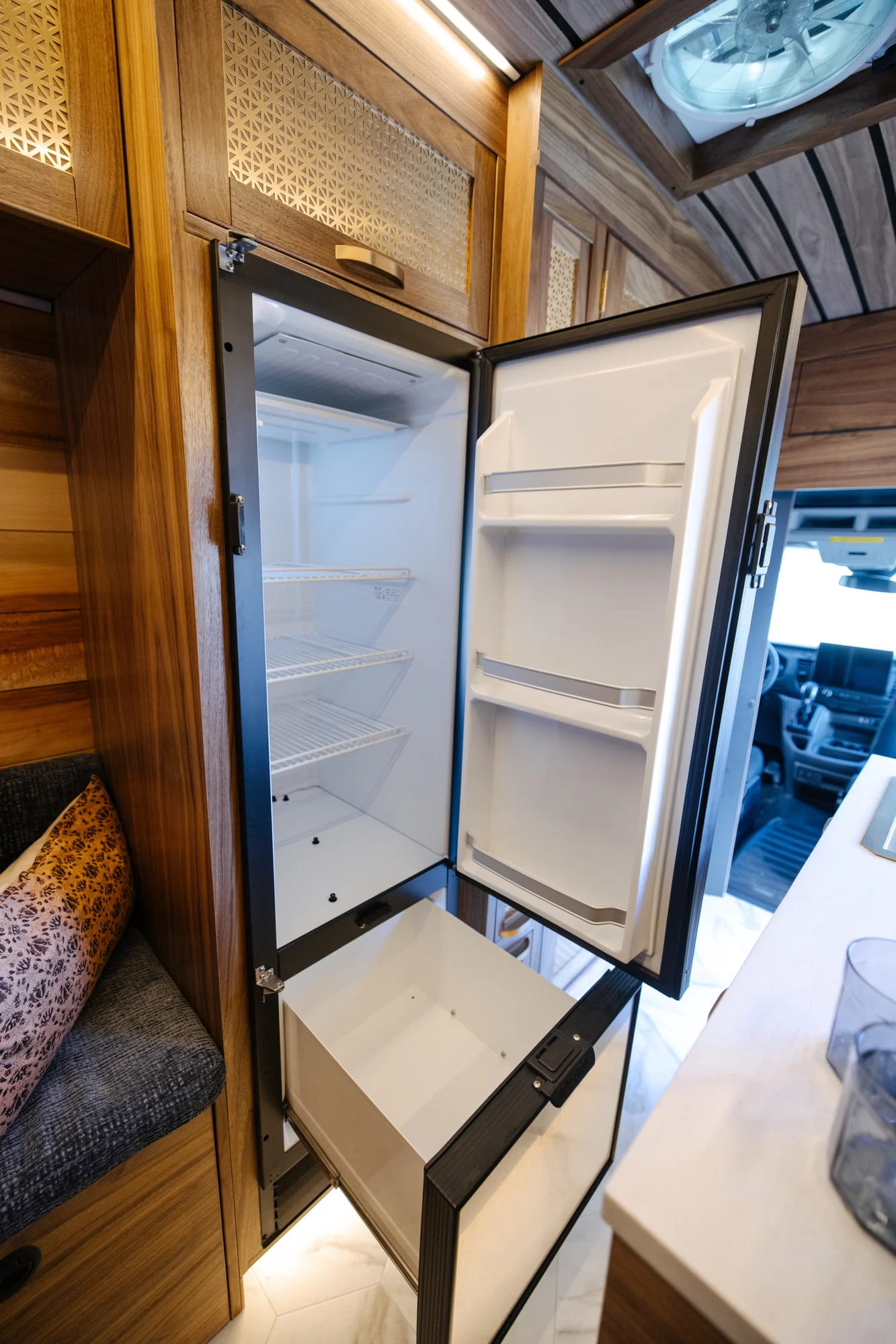 The Drifter 101 custom Ford Transit campervan built for Peter by Drifter Vans, with rich walnut cabinetry, brass mesh panels, and a tiled wet bath