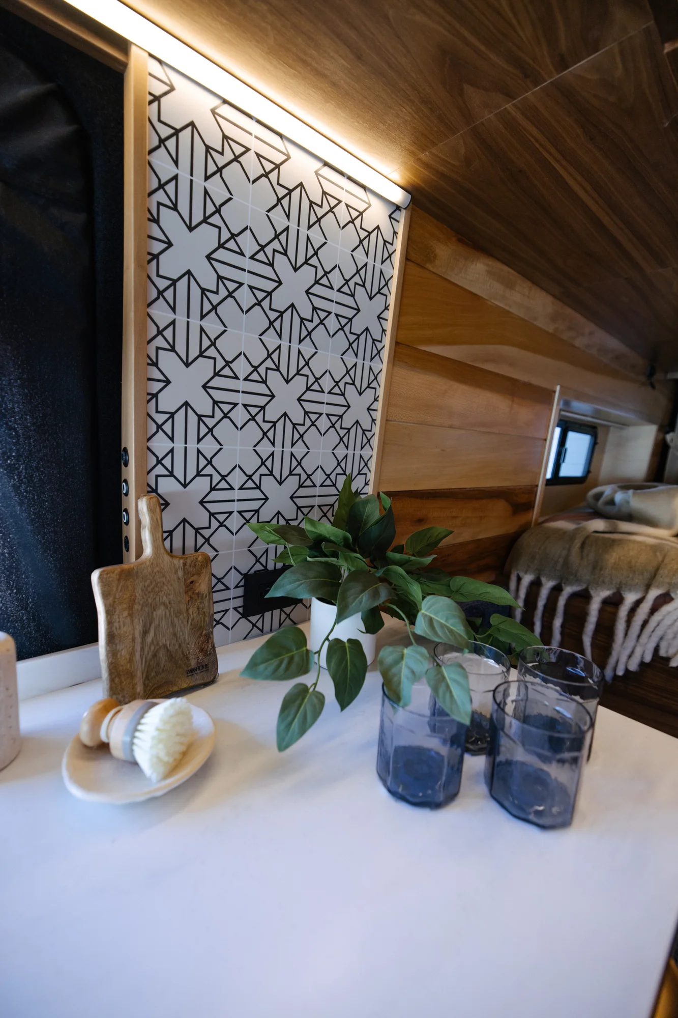 The Drifter 101 custom Ford Transit campervan built for Peter by Drifter Vans, with rich walnut cabinetry, brass mesh panels, and a tiled wet bath