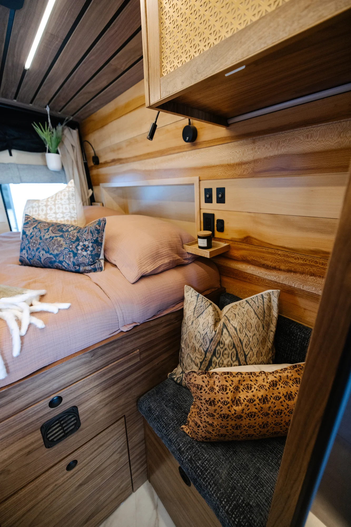 The Drifter 101 custom Ford Transit campervan built for Peter by Drifter Vans, with rich walnut cabinetry, brass mesh panels, and a tiled wet bath