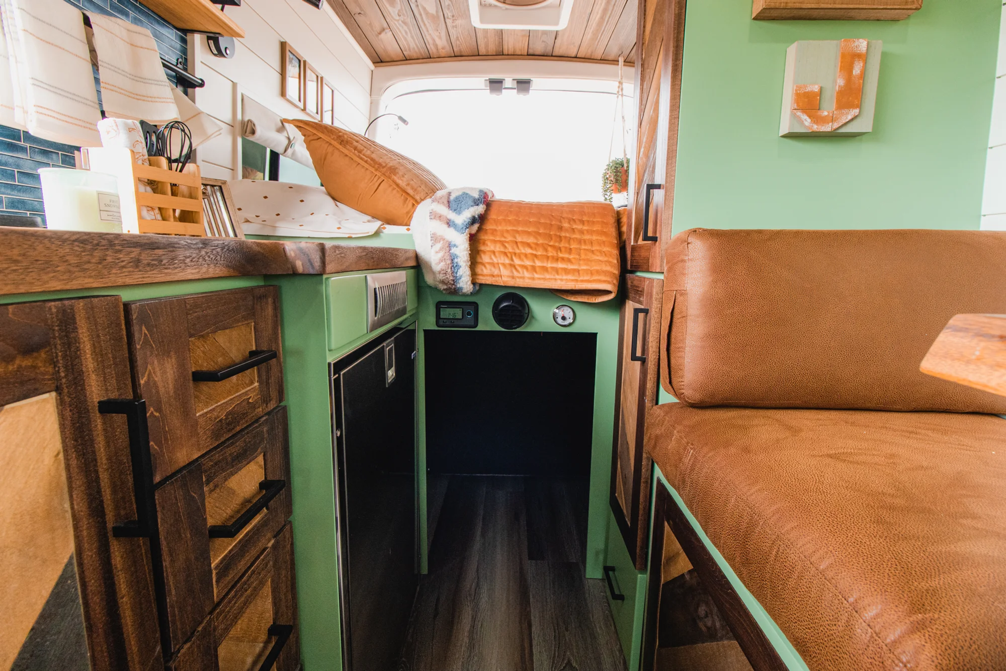 The Drifter 101 custom Ford Transit campervan built for Josh by Drifter Vans, Wanderer layout with forest green cabinetry, dark wood countertop, and leather booth seating