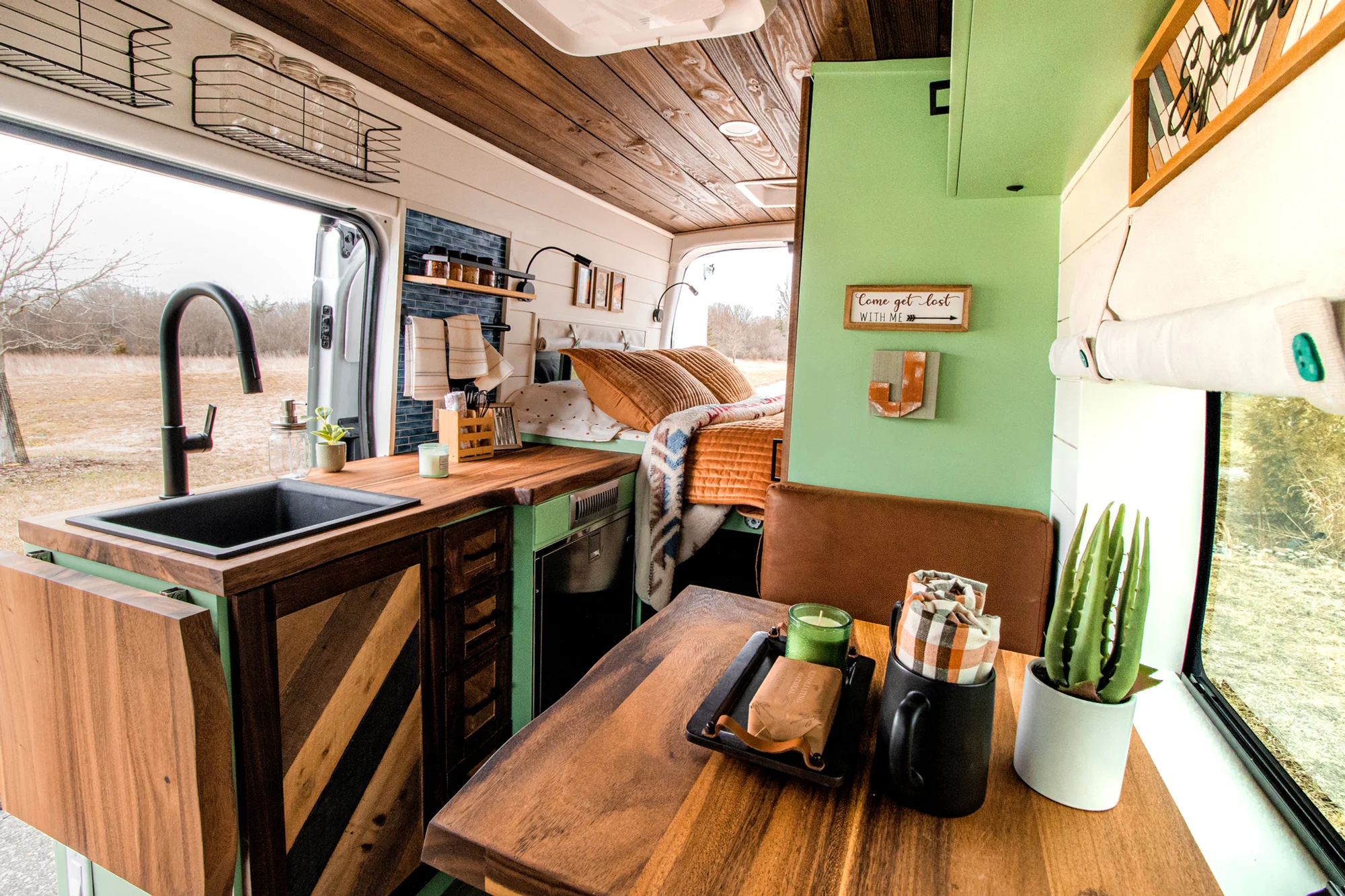 The Drifter 101 custom Ford Transit campervan built for Josh by Drifter Vans, Wanderer layout with forest green cabinetry, dark wood countertop, and leather booth seating