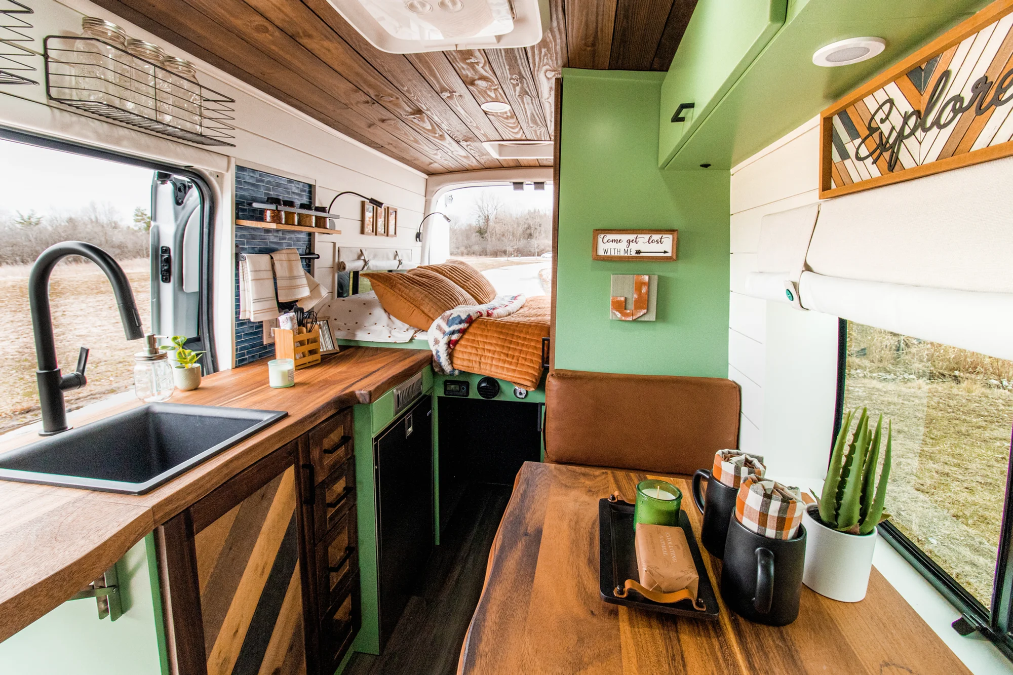 The Drifter 101 custom Ford Transit campervan built for Josh by Drifter Vans, Wanderer layout with forest green cabinetry, dark wood countertop, and leather booth seating