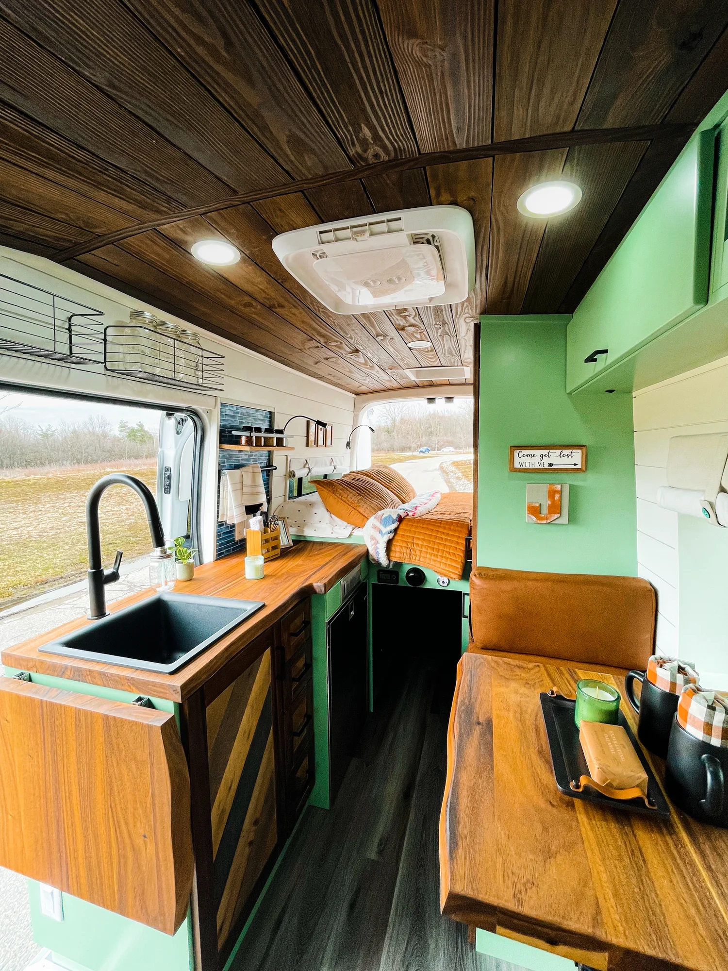 The Drifter 101 custom Ford Transit campervan built for Josh by Drifter Vans, Wanderer layout with forest green cabinetry, dark wood countertop, and leather booth seating