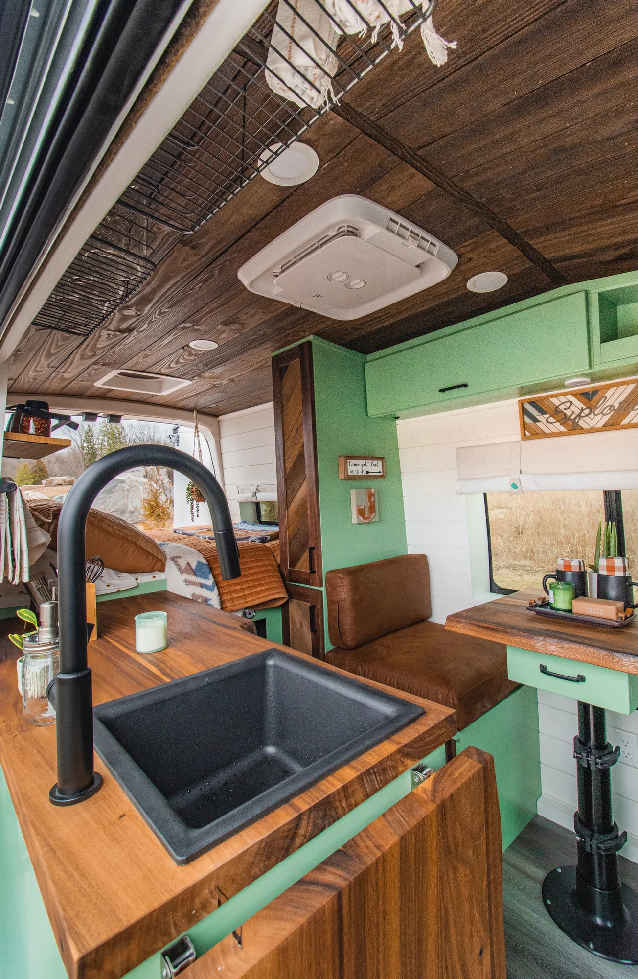 The Drifter 101 custom Ford Transit campervan built for Josh by Drifter Vans, Wanderer layout with forest green cabinetry, dark wood countertop, and leather booth seating
