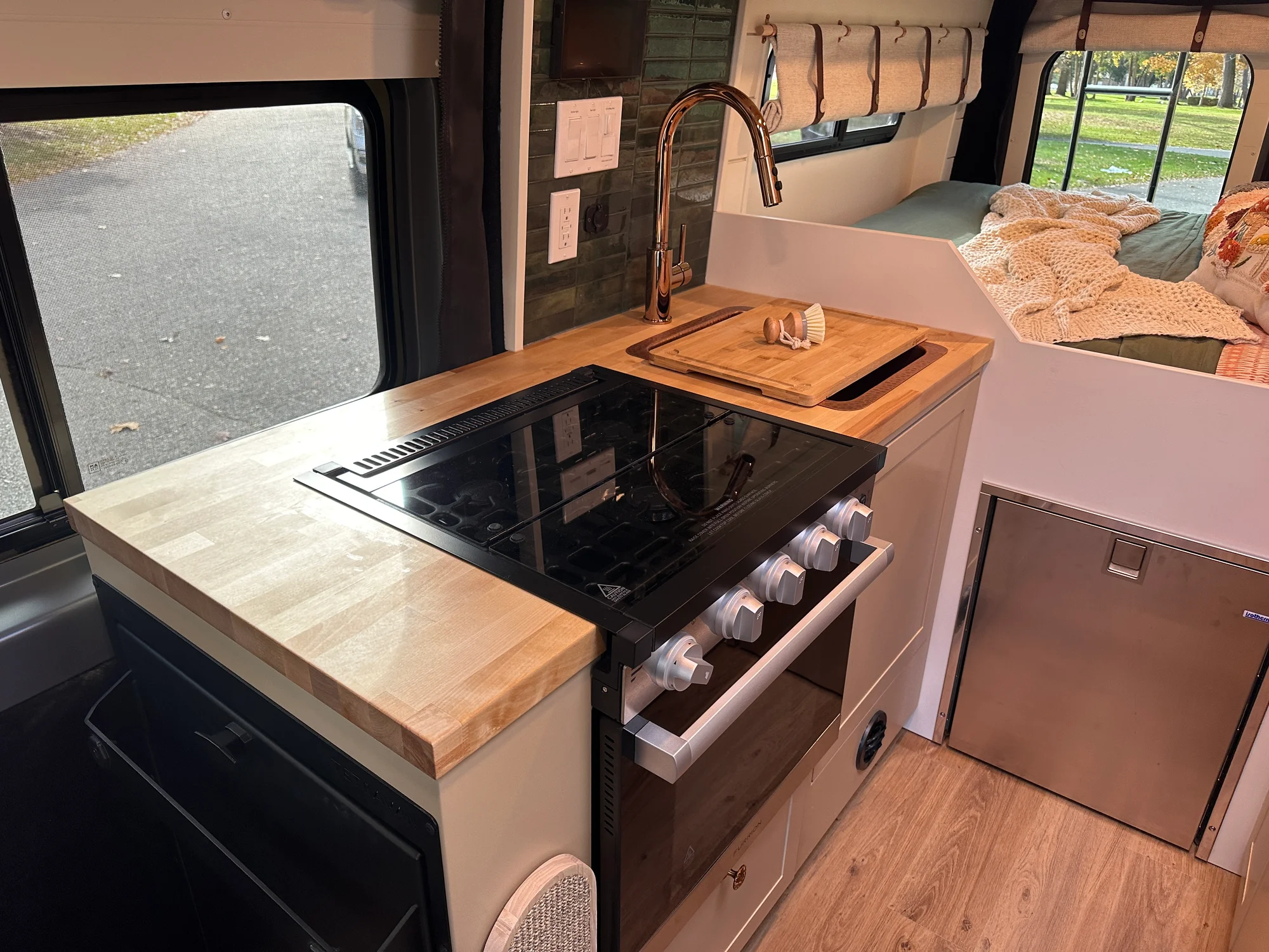 The Drifter 101 custom Ram ProMaster campervan built for Luke and Ashley by Drifter Vans, Drifter layout with a farmhouse interior, butcher block countertop, and wood ceiling