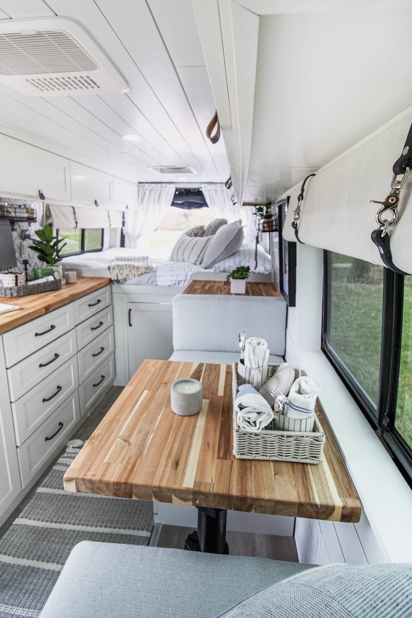 The Drifter 101 custom Ram ProMaster campervan built for Halley by Drifter Vans, Wanderer layout with a herringbone tile backsplash, butcher block countertop, and white cabinetry