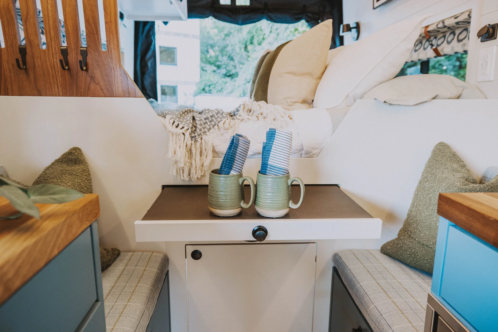 The Drifter 101 custom Ford Transit campervan built for Charlie and Linda by Drifter Vans, Nomadik layout with a Vermont slate shower, sky-blue cabinetry, and butcher block countertop