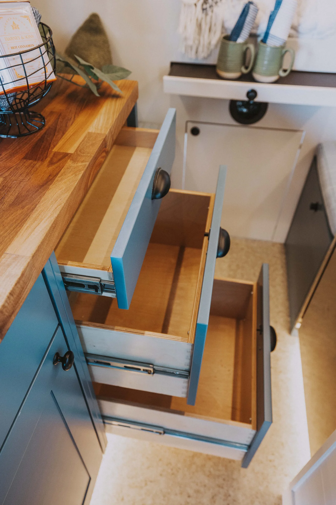 The Drifter 101 custom Ford Transit campervan built for Charlie and Linda by Drifter Vans, Nomadik layout with a Vermont slate shower, sky-blue cabinetry, and butcher block countertop