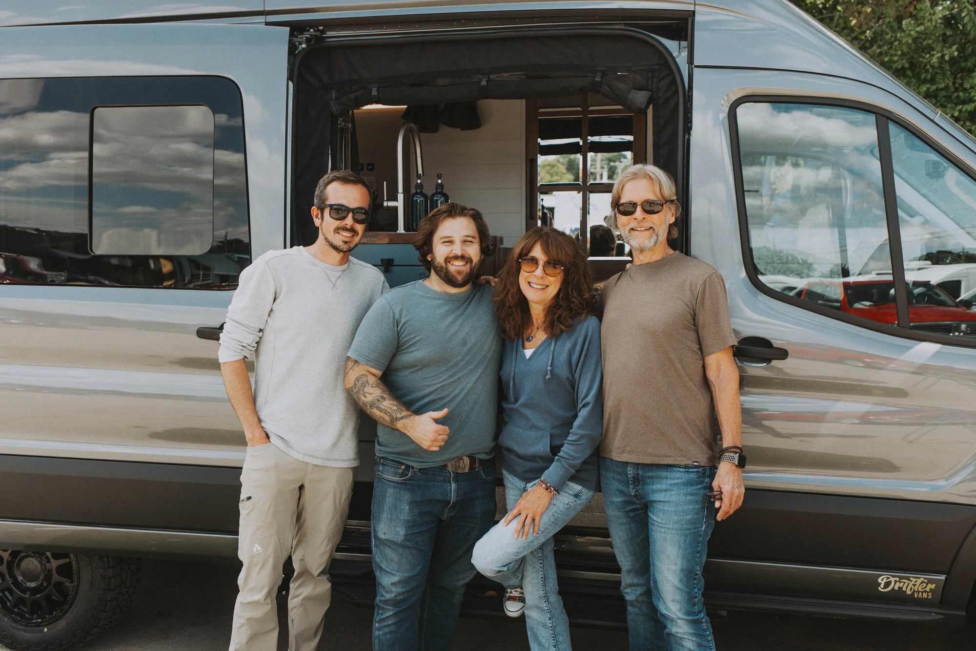 The Drifter 101 custom Ford Transit campervan built for Charlie and Linda by Drifter Vans, Nomadik layout with a Vermont slate shower, sky-blue cabinetry, and butcher block countertop