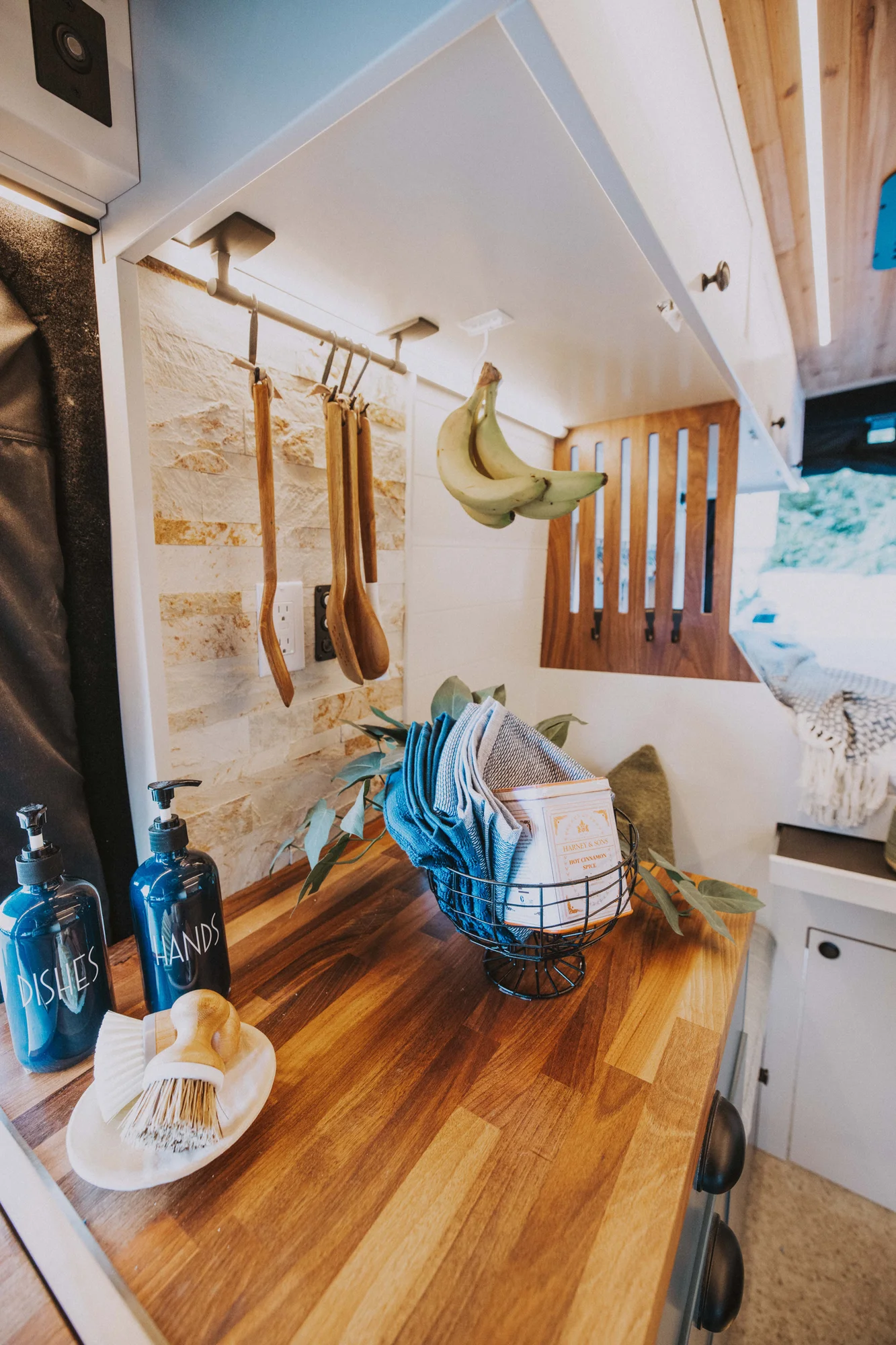 The Drifter 101 custom Ford Transit campervan built for Charlie and Linda by Drifter Vans, Nomadik layout with a Vermont slate shower, sky-blue cabinetry, and butcher block countertop