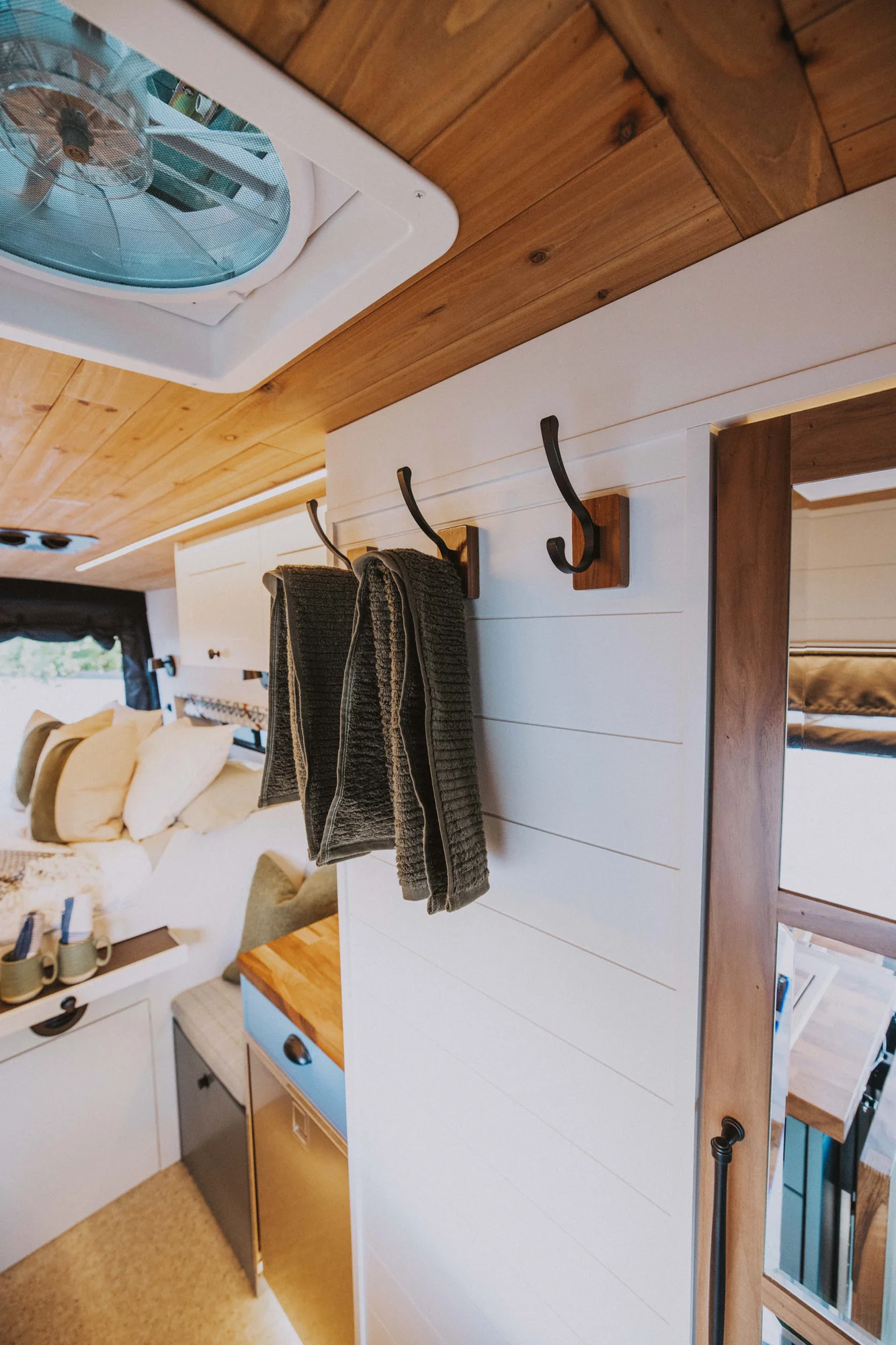 The Drifter 101 custom Ford Transit campervan built for Charlie and Linda by Drifter Vans, Nomadik layout with a Vermont slate shower, sky-blue cabinetry, and butcher block countertop