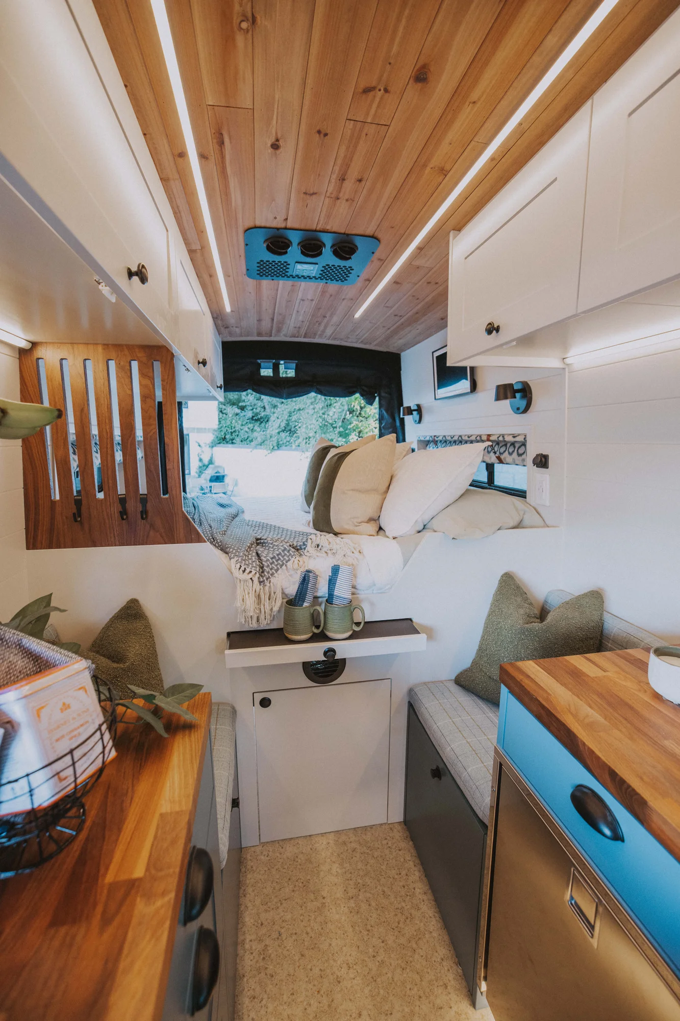 The Drifter 101 custom Ford Transit campervan built for Charlie and Linda by Drifter Vans, Nomadik layout with a Vermont slate shower, sky-blue cabinetry, and butcher block countertop