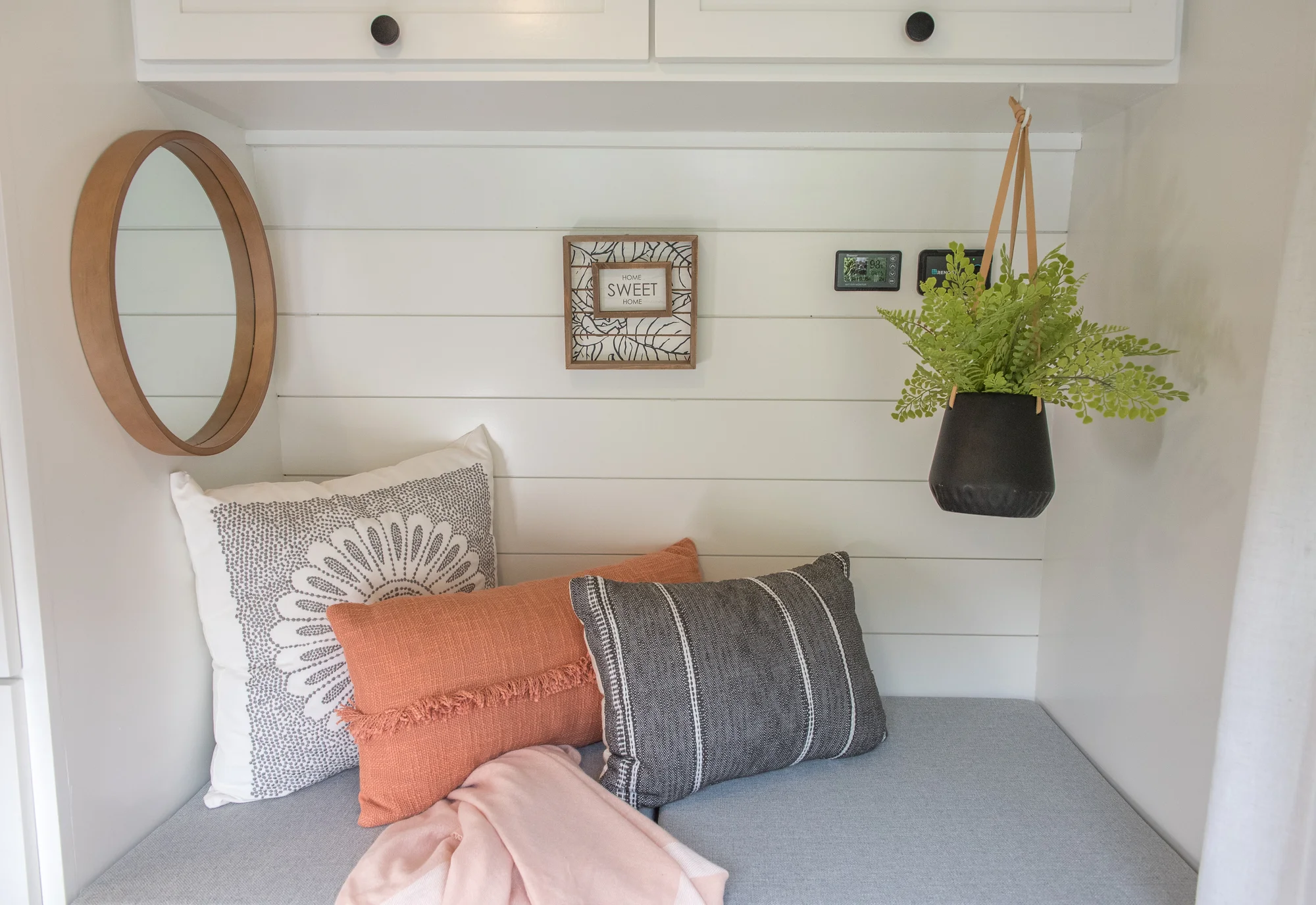The Drifter 101 custom Ram ProMaster campervan built for Marcia by Drifter Vans, with white shiplap walls, wood countertop, an enclosed shower, and a remote work setup