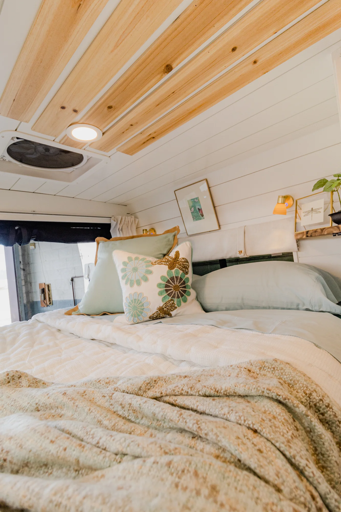 The Drifter 101 custom Ram ProMaster campervan built for Rhonda by Drifter Vans, Wanderer layout with a boho interior, Furrion oven, blue patterned tile backsplash, and brass hardware