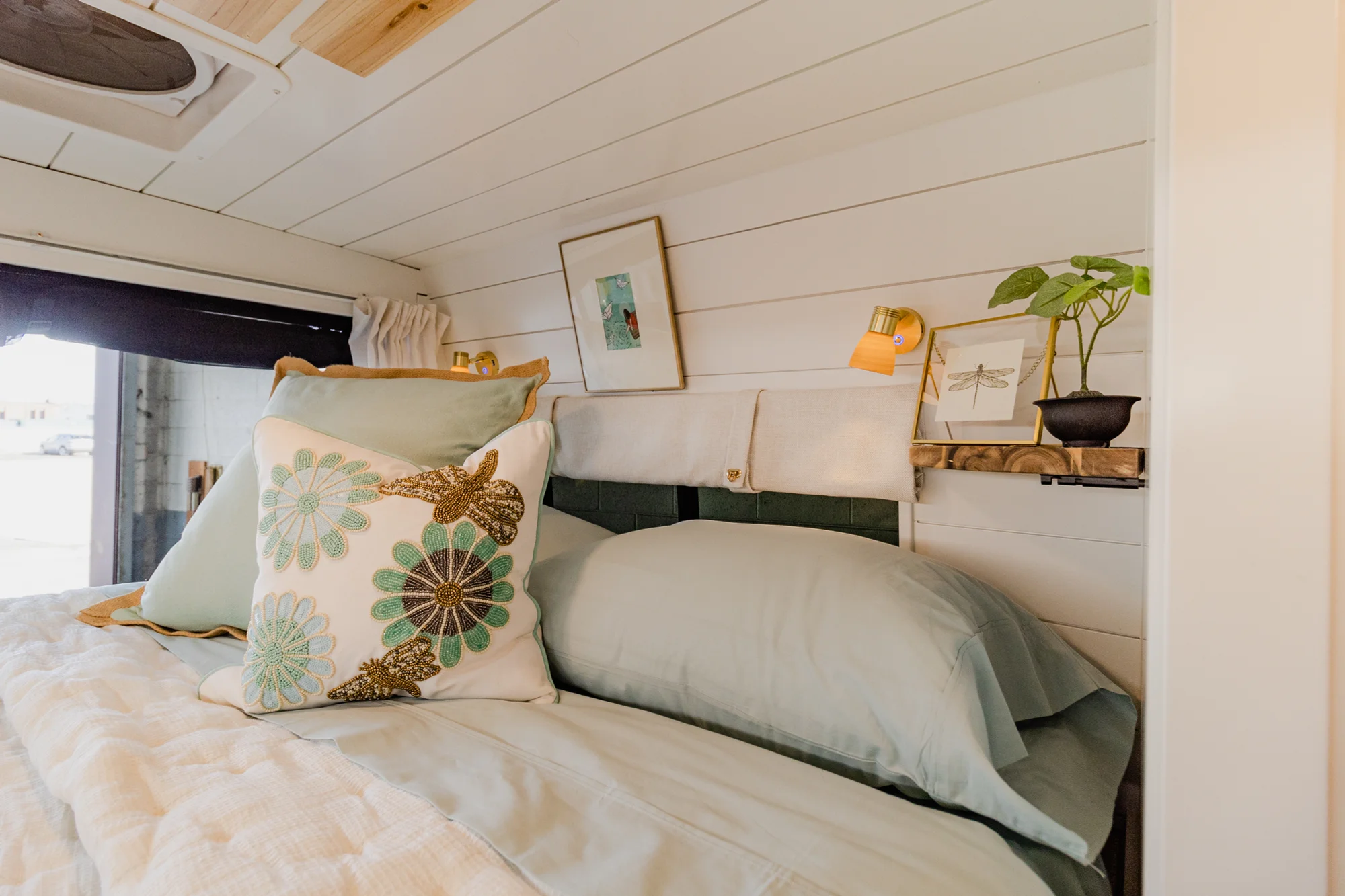 The Drifter 101 custom Ram ProMaster campervan built for Rhonda by Drifter Vans, Wanderer layout with a boho interior, Furrion oven, blue patterned tile backsplash, and brass hardware