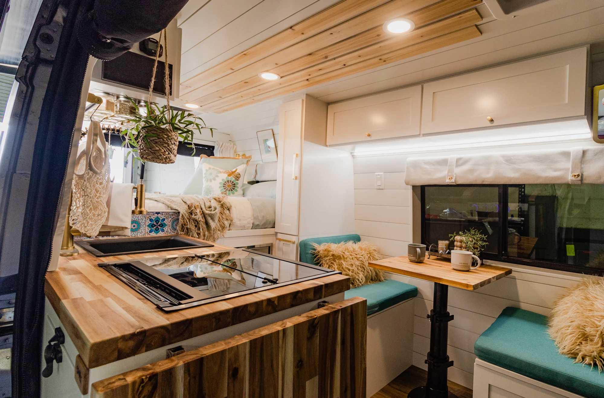 The Drifter 101 custom Ram ProMaster campervan built for Rhonda by Drifter Vans, Wanderer layout with a boho interior, Furrion oven, blue patterned tile backsplash, and brass hardware