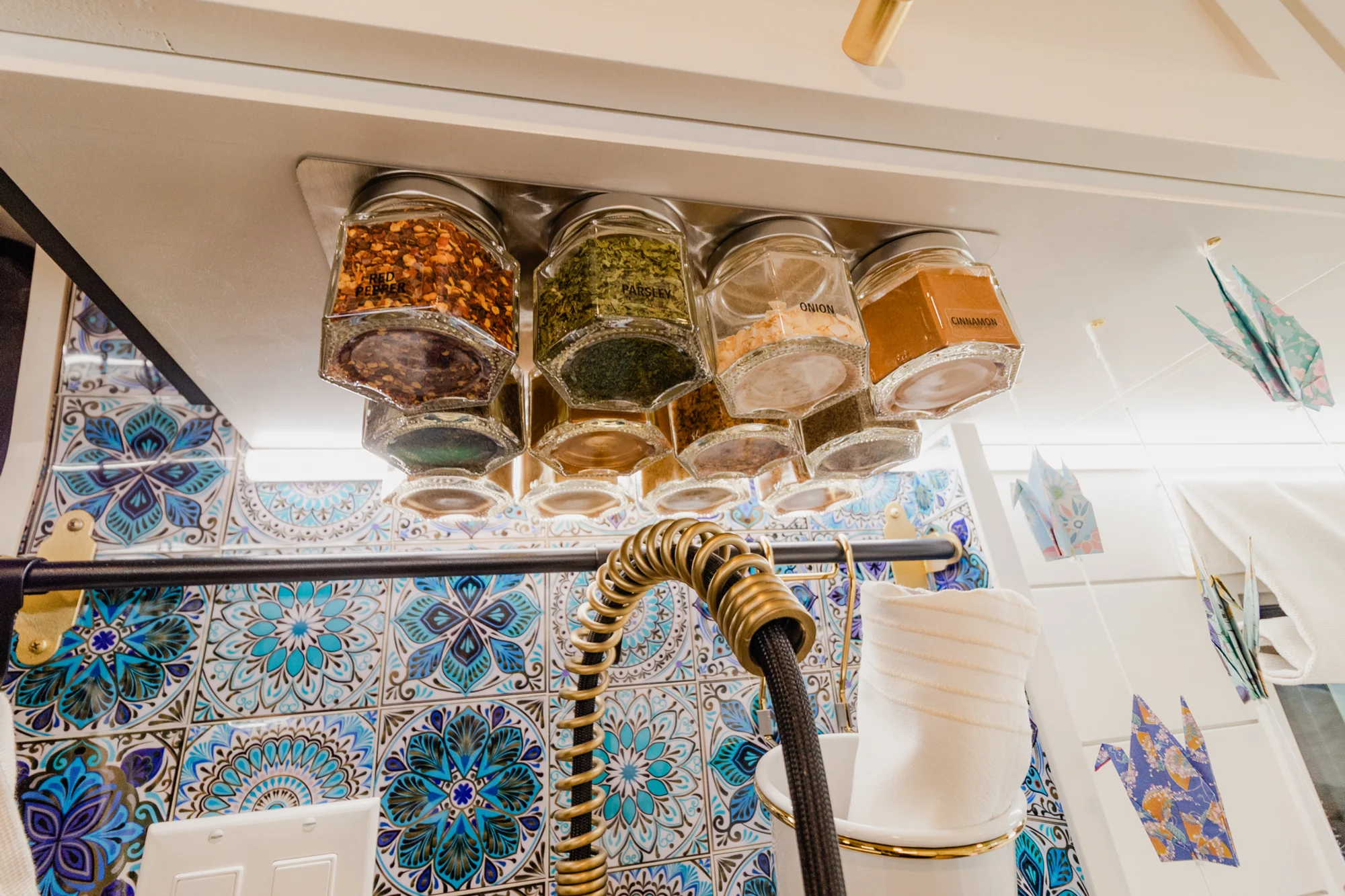 The Drifter 101 custom Ram ProMaster campervan built for Rhonda by Drifter Vans, Wanderer layout with a boho interior, Furrion oven, blue patterned tile backsplash, and brass hardware
