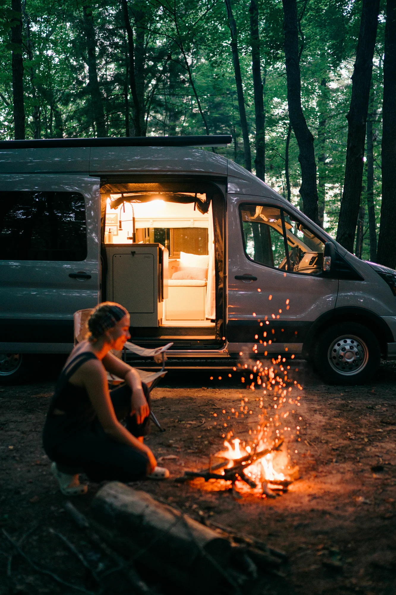 The Drifter 101 custom Ford Transit campervan built for Heather by Drifter Vans, Drifter layout with a full oven, patterned tile backsplash, brass faucet, and natural wood cabinetry
