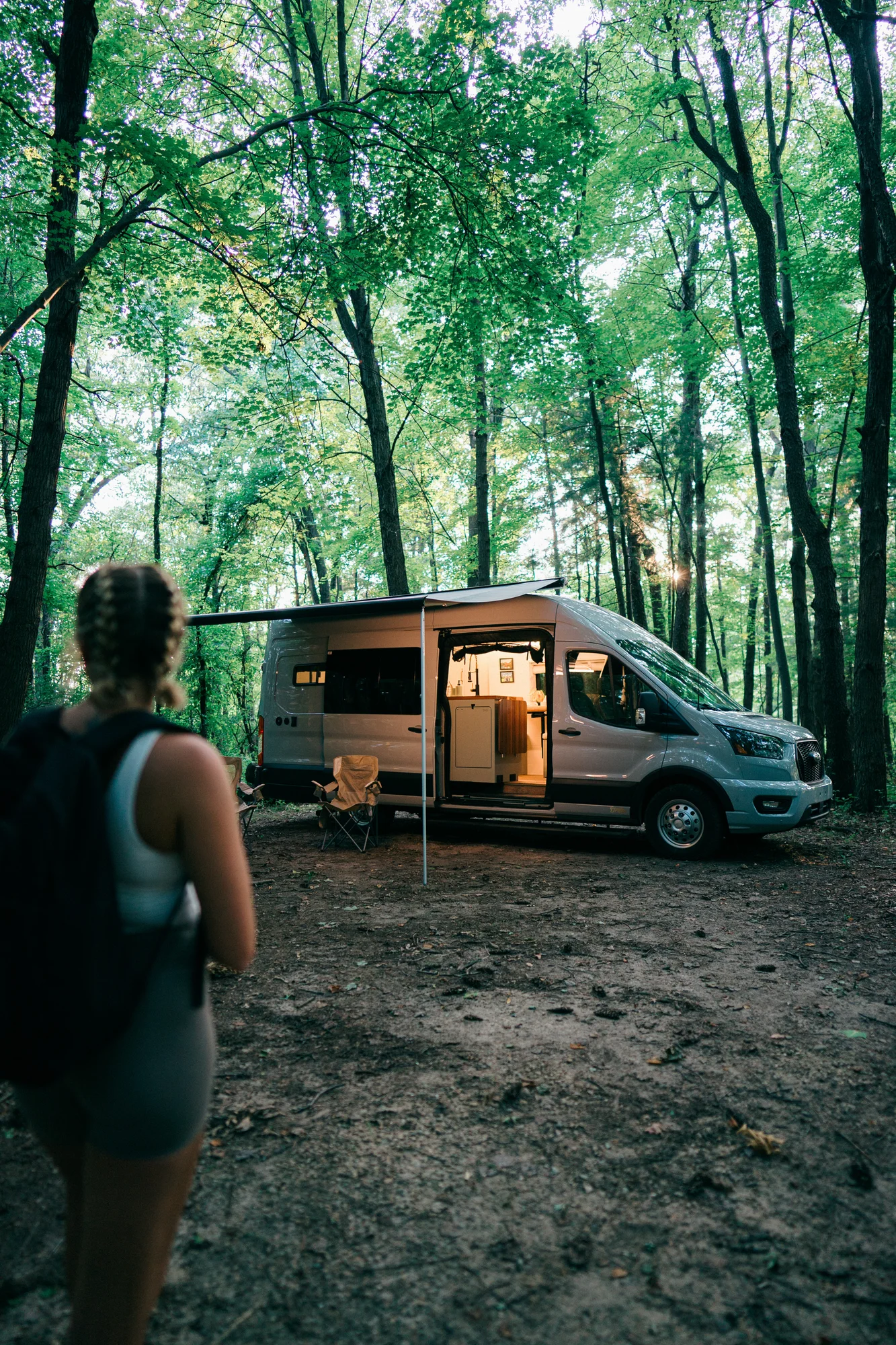 The Drifter 101 custom Ford Transit campervan built for Heather by Drifter Vans, Drifter layout with a full oven, patterned tile backsplash, brass faucet, and natural wood cabinetry