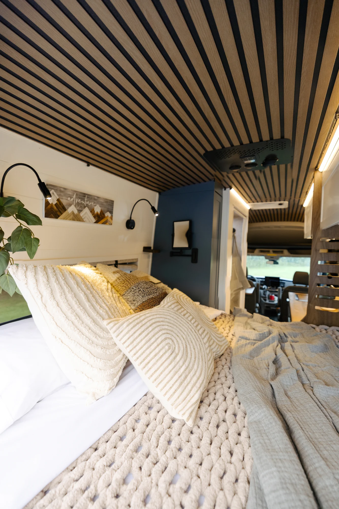 The Drifter 101 custom Ford Transit campervan built for Karen and Jerry by Drifter Vans, Scout layout with navy blue cabinetry, a mountain-engraved backsplash, and butcher block countertop