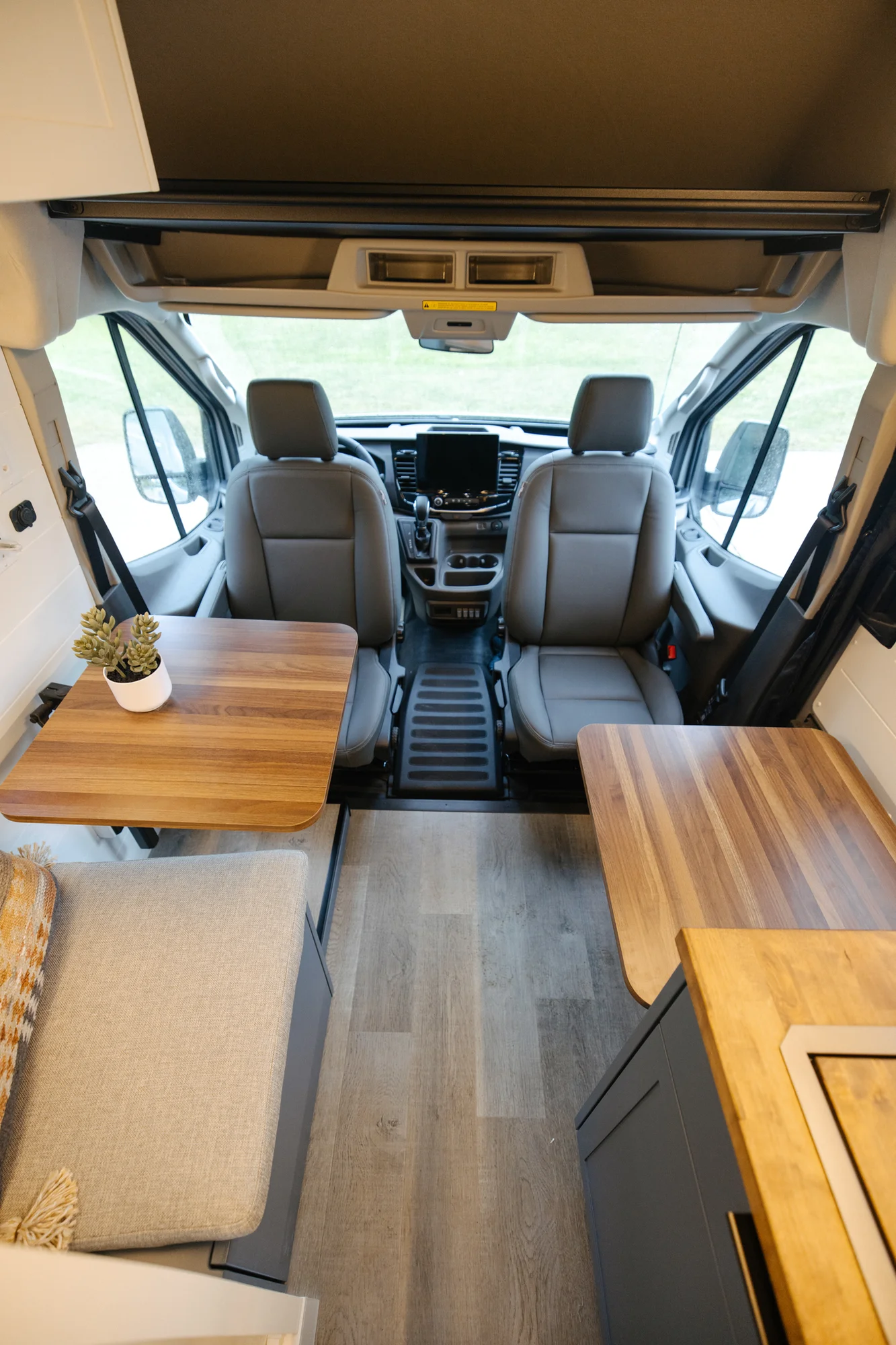 The Drifter 101 custom Ford Transit campervan built for Karen and Jerry by Drifter Vans, Scout layout with navy blue cabinetry, a mountain-engraved backsplash, and butcher block countertop
