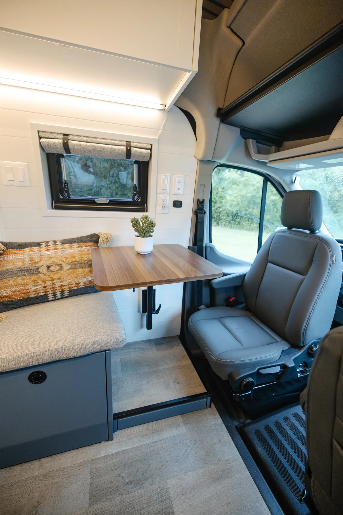 The Drifter 101 custom Ford Transit campervan built for Karen and Jerry by Drifter Vans, Scout layout with navy blue cabinetry, a mountain-engraved backsplash, and butcher block countertop