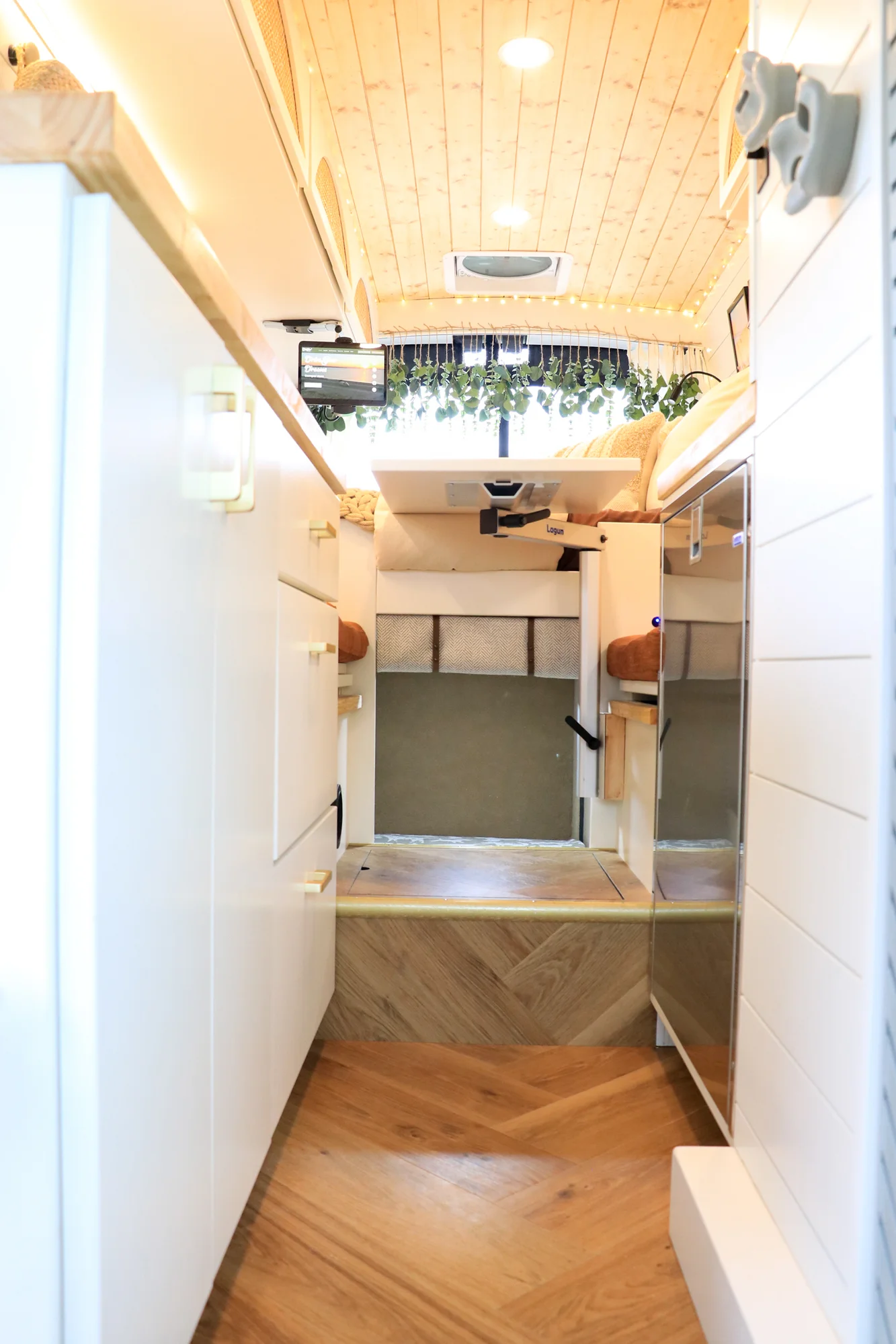 The Drifter 101 custom Ford Transit campervan built for Sarah by Drifter Vans, Nomadik layout with a marble-style wet bath, gold faucet, trifold privacy door, and boho accents