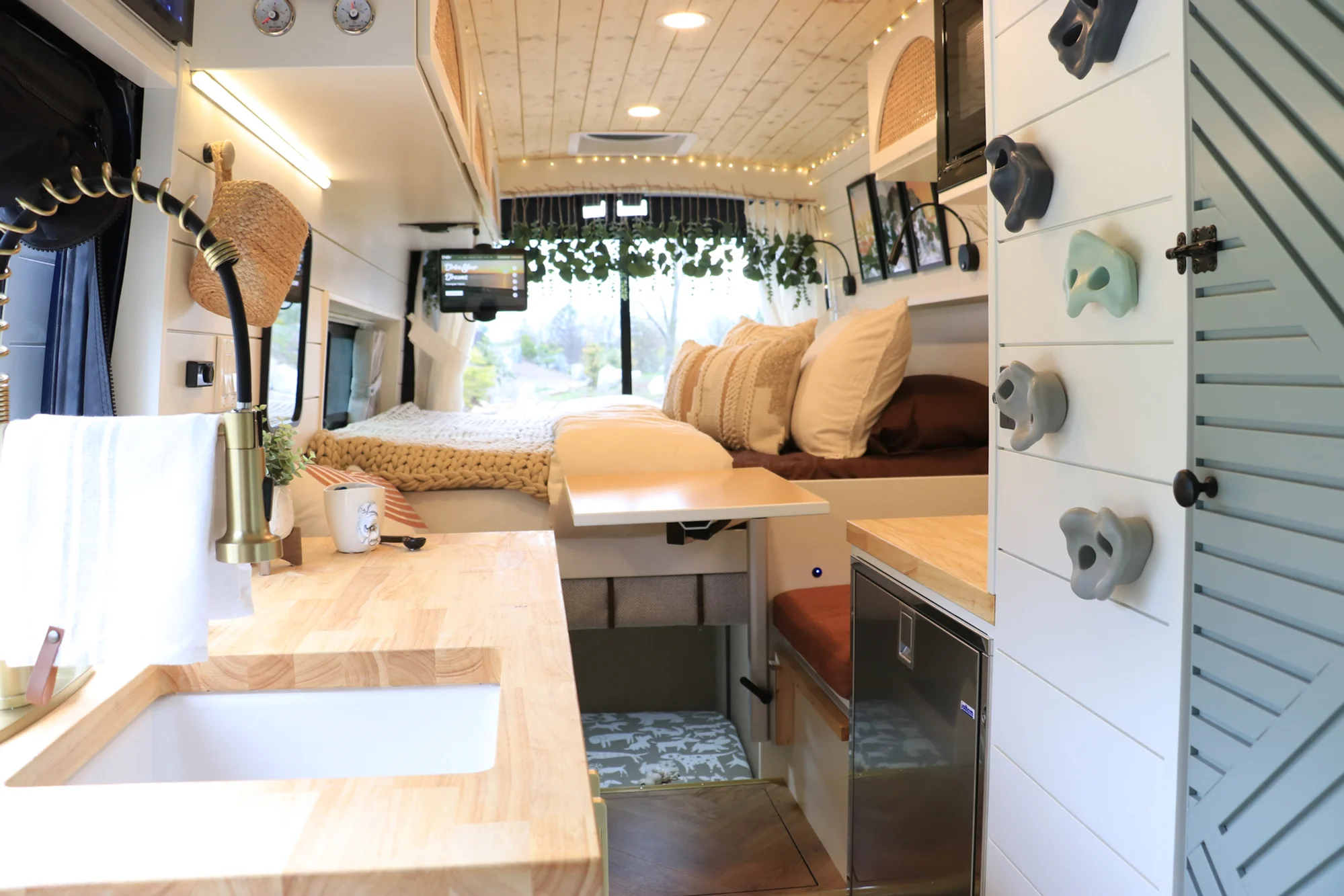 The Drifter 101 custom Ford Transit campervan built for Sarah by Drifter Vans, Nomadik layout with a marble-style wet bath, gold faucet, trifold privacy door, and boho accents