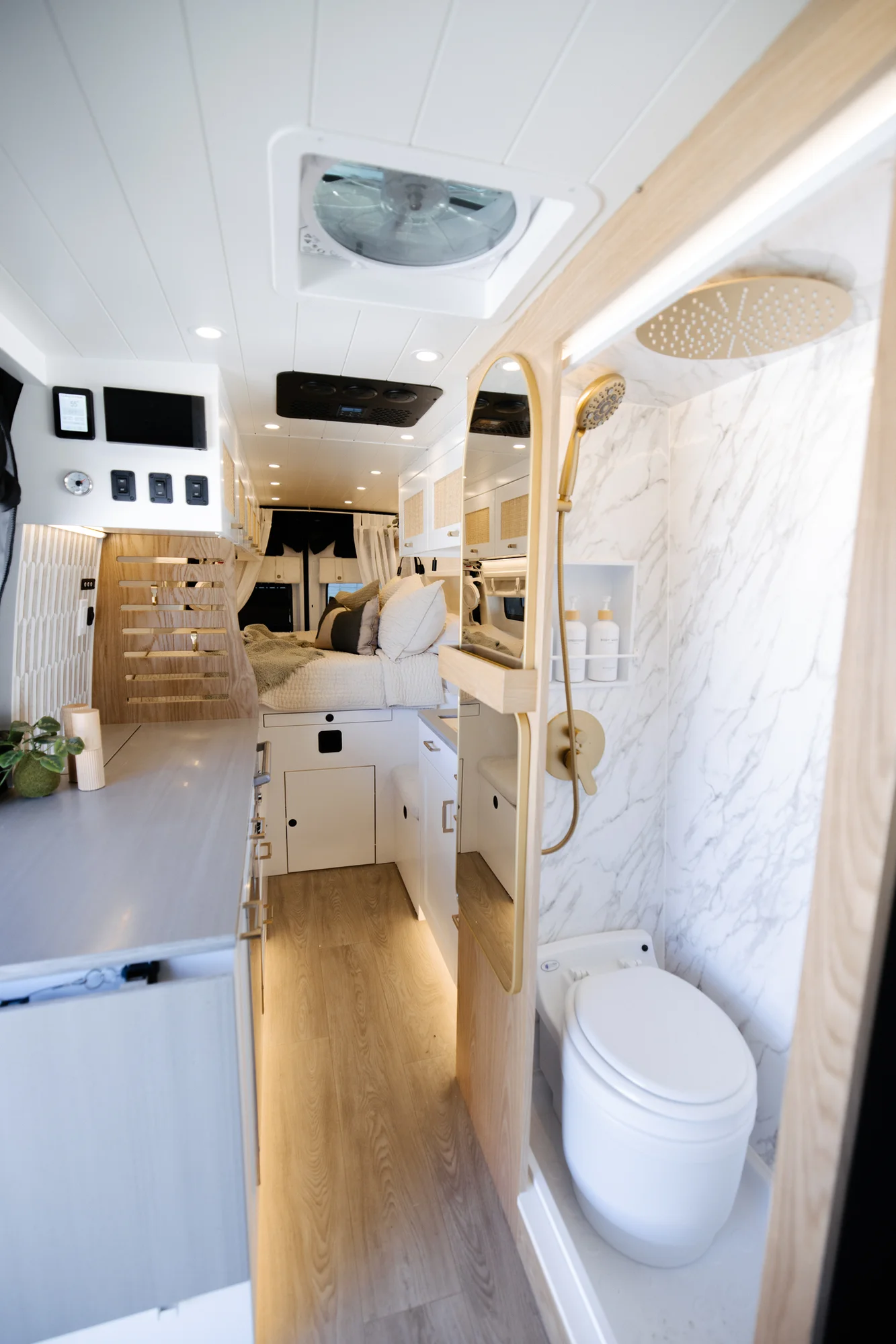 The Drifter 101 custom Ford Transit campervan built for Alison by Drifter Vans, Nomadik layout with a Japandi interior, white cabinetry, gold rain shower, and marble wet bath