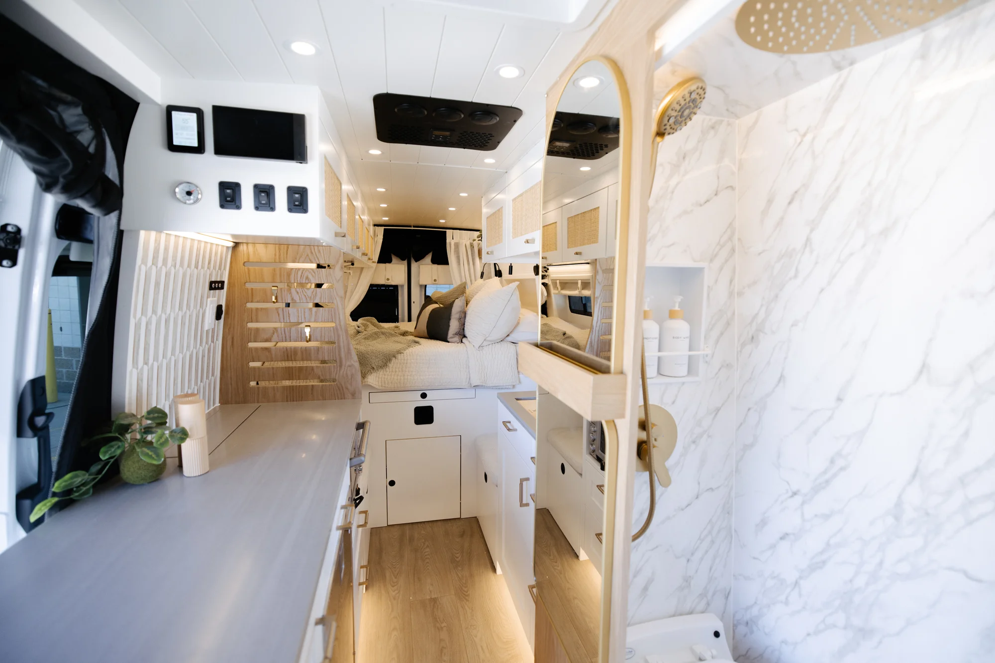 The Drifter 101 custom Ford Transit campervan built for Alison by Drifter Vans, Nomadik layout with a Japandi interior, white cabinetry, gold rain shower, and marble wet bath