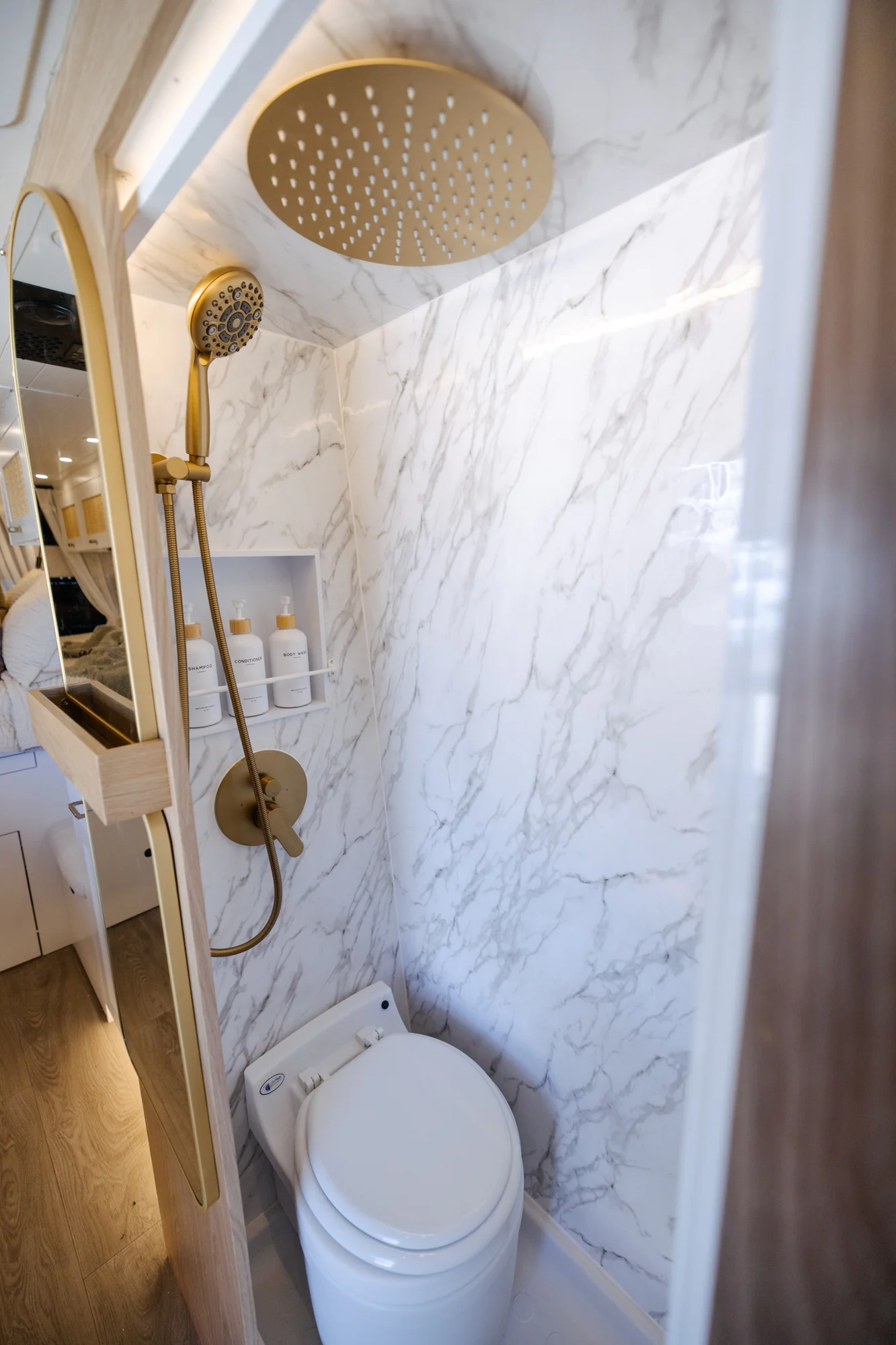 The Drifter 101 custom Ford Transit campervan built for Alison by Drifter Vans, Nomadik layout with a Japandi interior, white cabinetry, gold rain shower, and marble wet bath