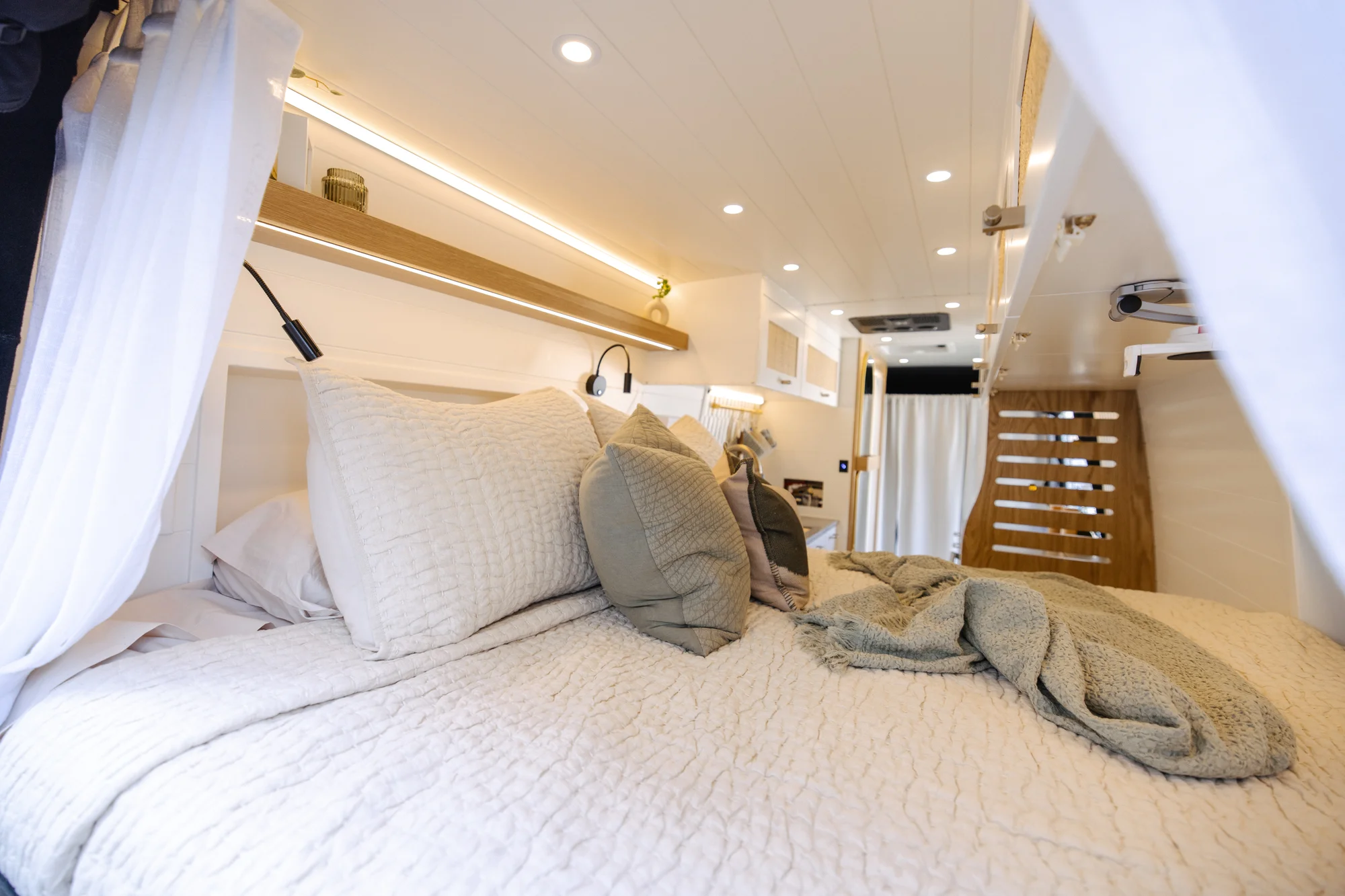 The Drifter 101 custom Ford Transit campervan built for Alison by Drifter Vans, Nomadik layout with a Japandi interior, white cabinetry, gold rain shower, and marble wet bath