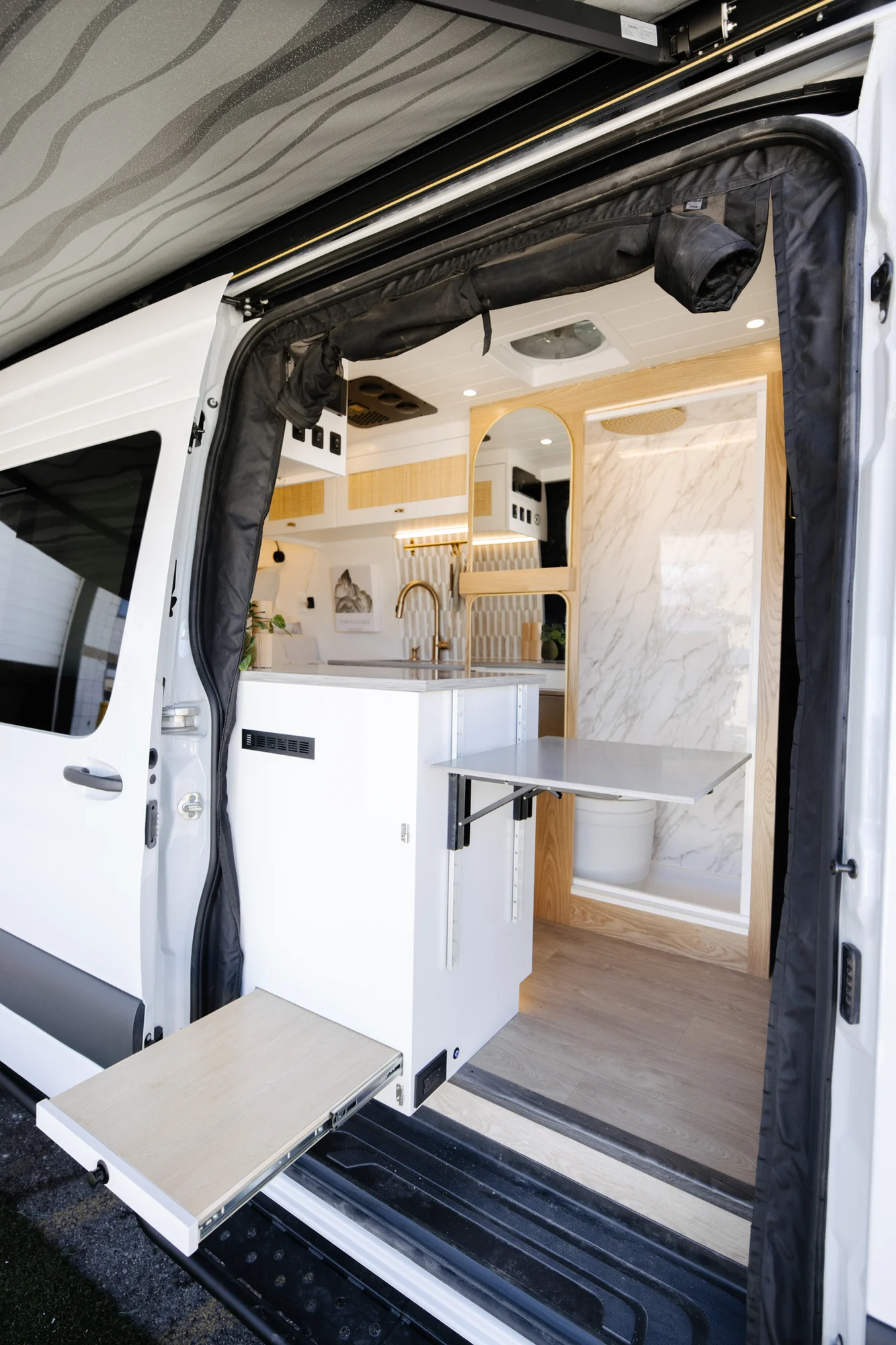 The Drifter 101 custom Ford Transit campervan built for Alison by Drifter Vans, Nomadik layout with a Japandi interior, white cabinetry, gold rain shower, and marble wet bath