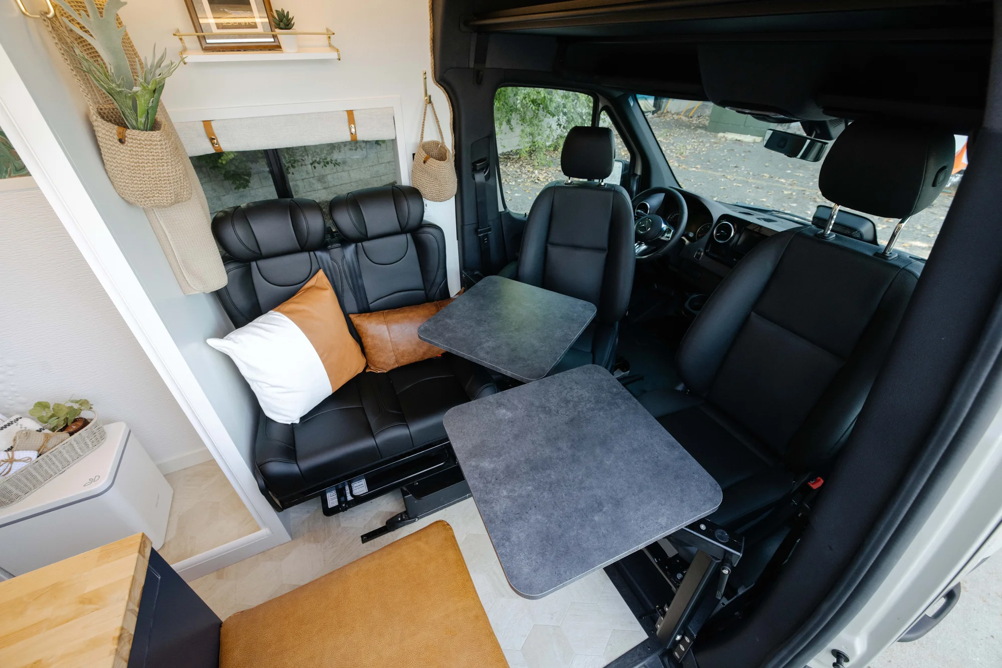 The Drifter 101 custom Mercedes-Benz Sprinter campervan built for Amber by Drifter Vans, with a pop-top sleeping area, navy cabinetry, butcher block counters, and gold hardware