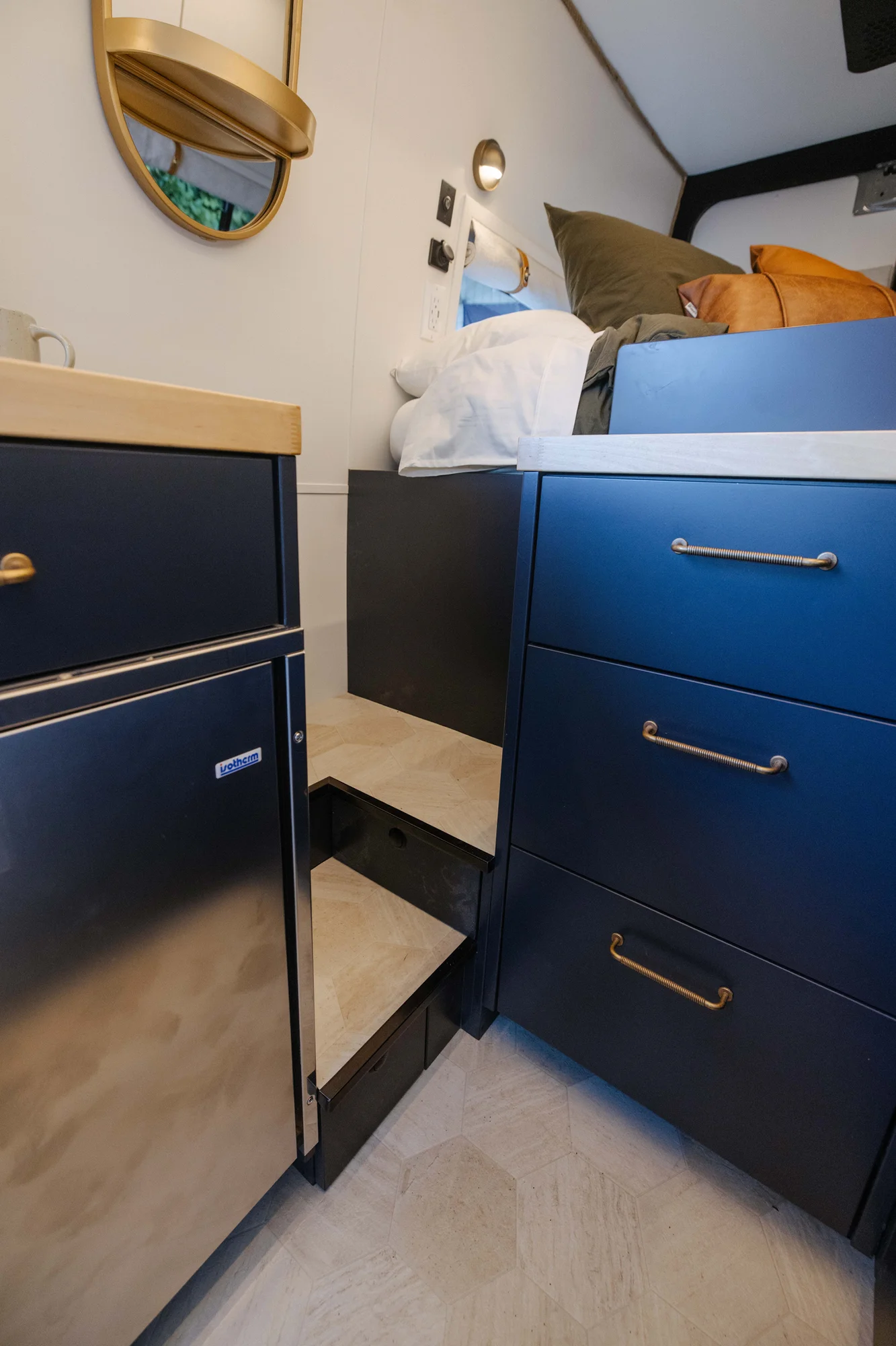 The Drifter 101 custom Mercedes-Benz Sprinter campervan built for Amber by Drifter Vans, with a pop-top sleeping area, navy cabinetry, butcher block counters, and gold hardware