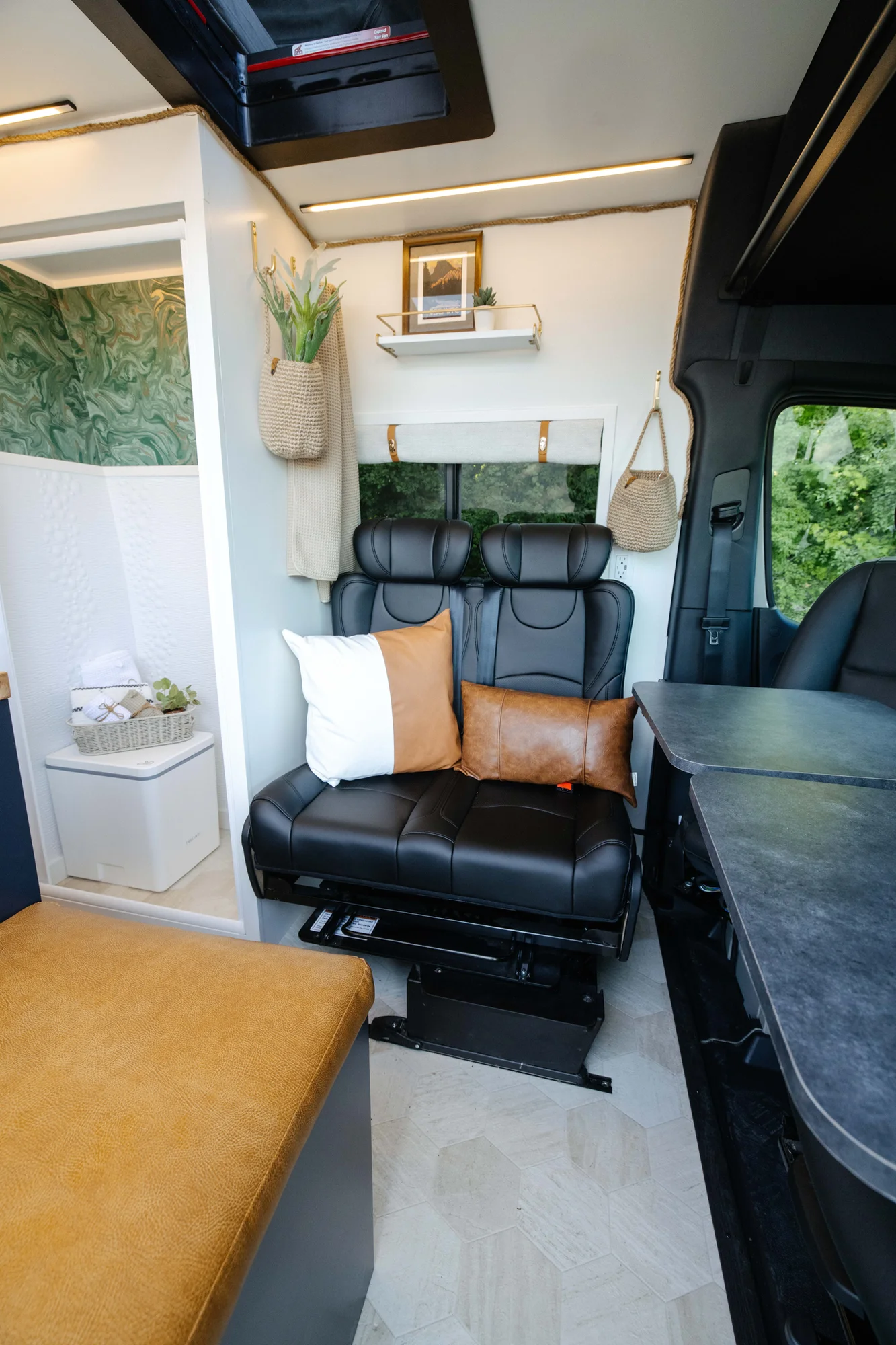 The Drifter 101 custom Mercedes-Benz Sprinter campervan built for Amber by Drifter Vans, with a pop-top sleeping area, navy cabinetry, butcher block counters, and gold hardware