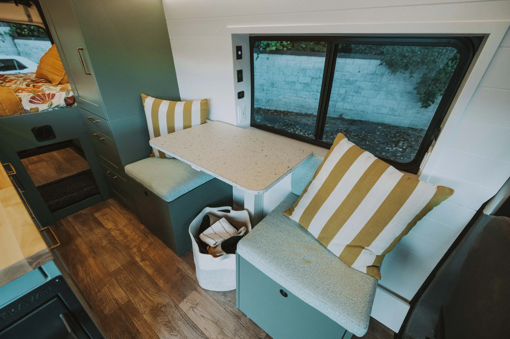 The Drifter 101 custom Ford Transit campervan built for Kristina by Drifter Vans, Drifter layout with a Moroccan-inspired blue tile backsplash, warm wood cabinetry, and a built-in dog nook