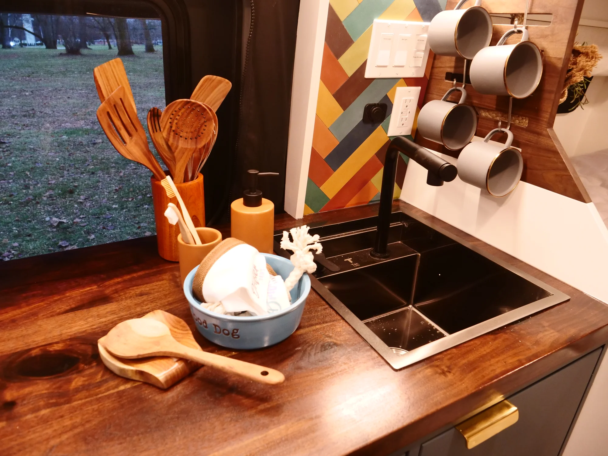 The Drifter 101 custom Ford Transit campervan built for Lynne by Drifter Vans, Drifter layout with a mid-century modern interior, dark walnut countertop, and gold hardware