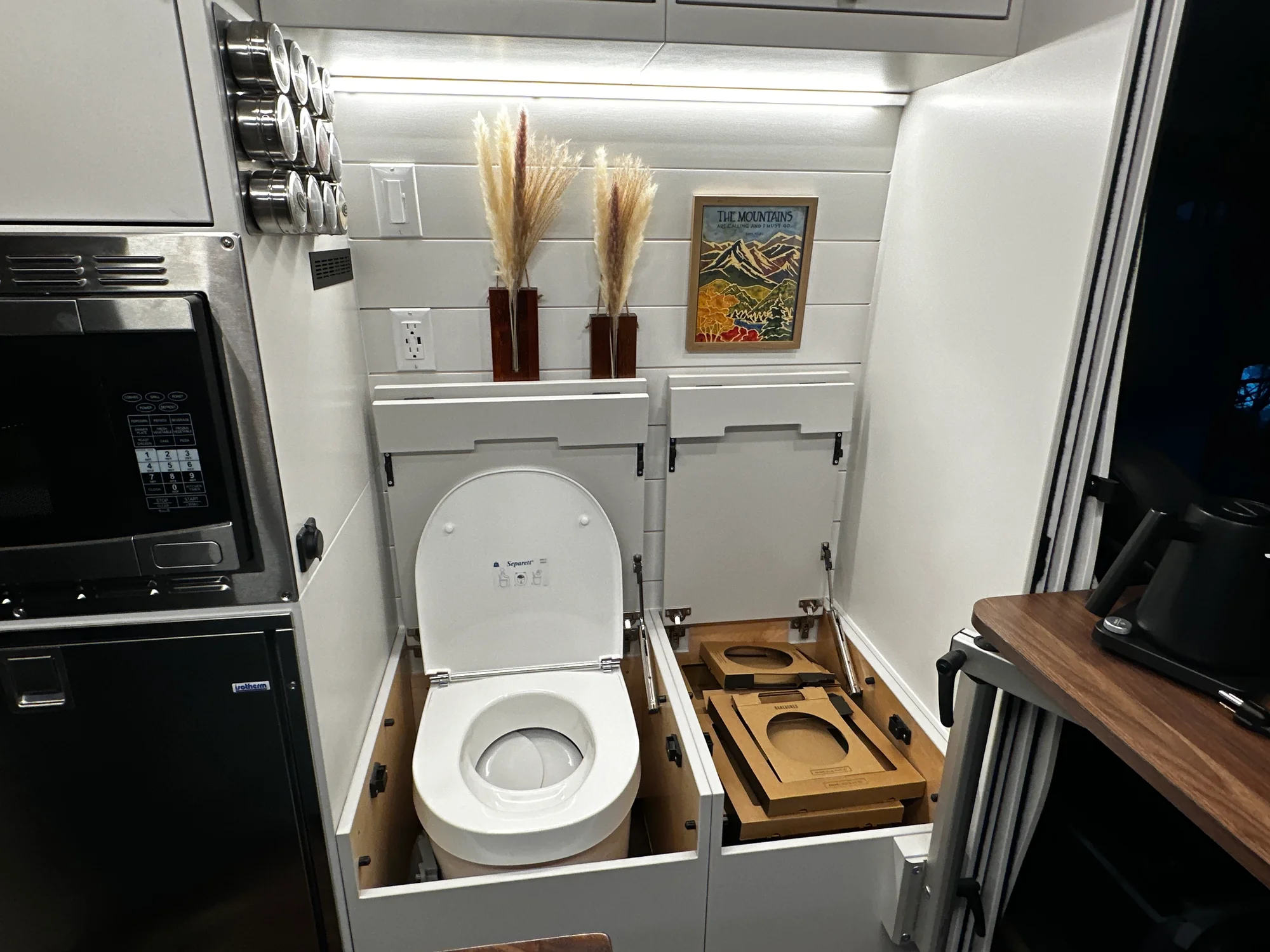 The Drifter 101 custom Ford Transit campervan built for Lynne by Drifter Vans, Drifter layout with a mid-century modern interior, dark walnut countertop, and gold hardware