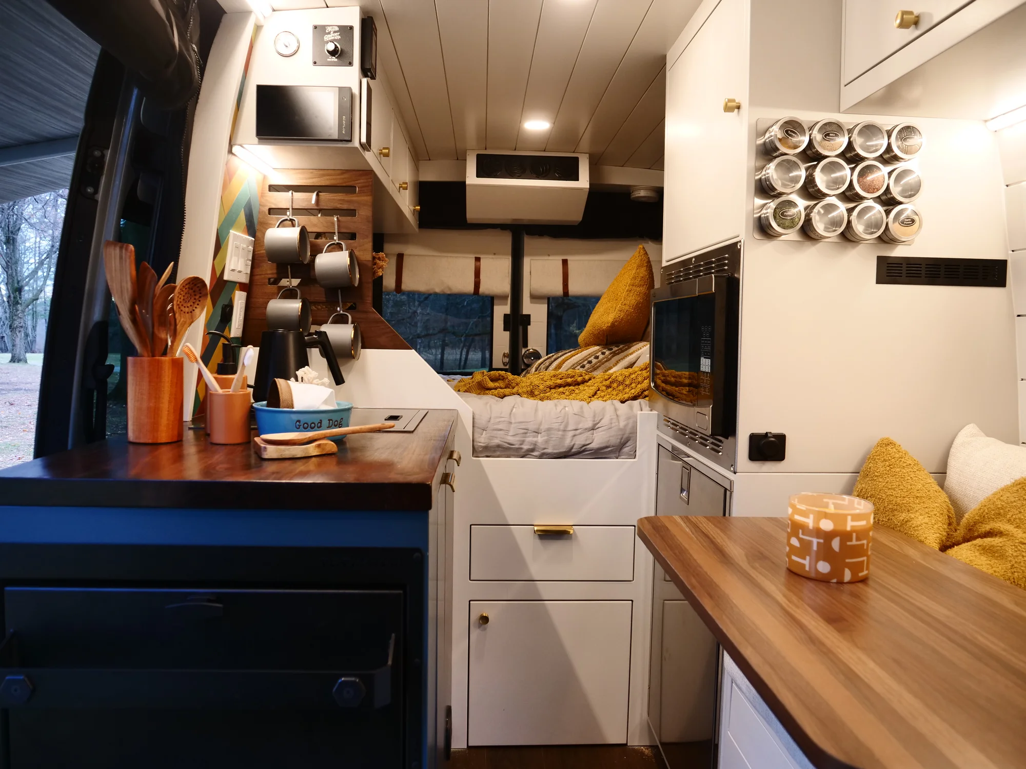 The Drifter 101 custom Ford Transit campervan built for Lynne by Drifter Vans, Drifter layout with a mid-century modern interior, dark walnut countertop, and gold hardware