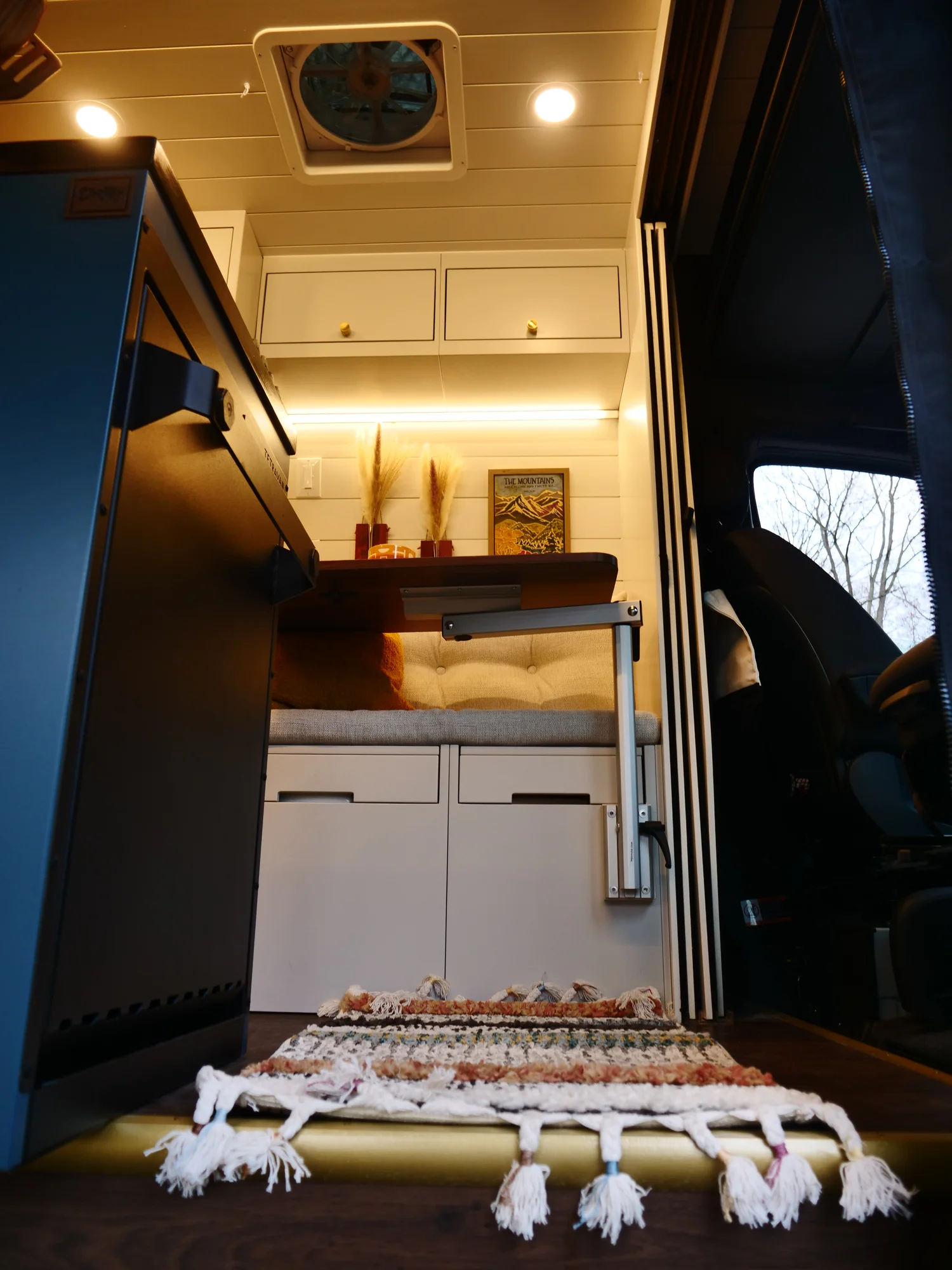 The Drifter 101 custom Ford Transit campervan built for Lynne by Drifter Vans, Drifter layout with a mid-century modern interior, dark walnut countertop, and gold hardware